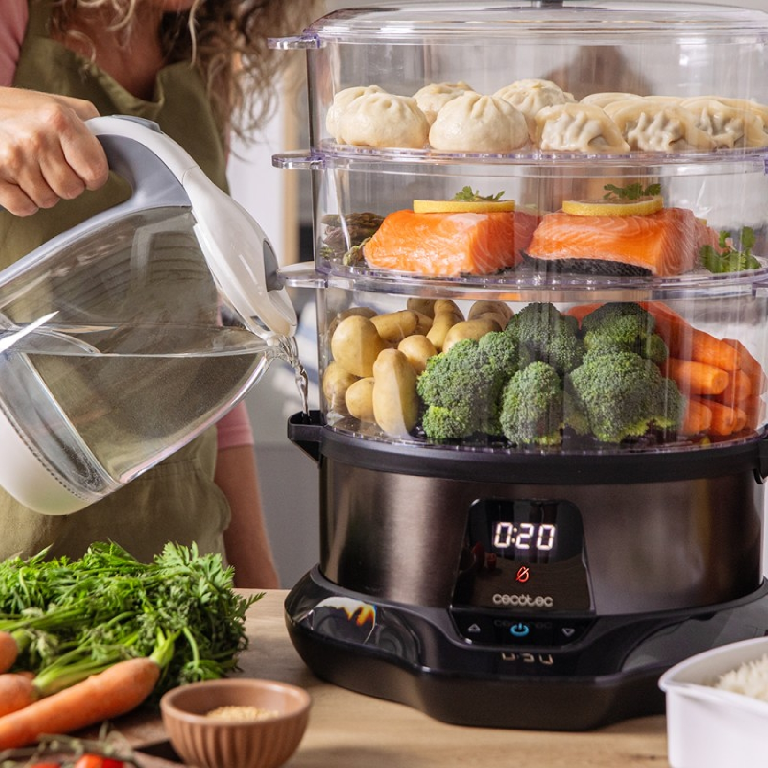 Una persona versa acqua in un vaporizzatore con pesce, verdure e ravioli.