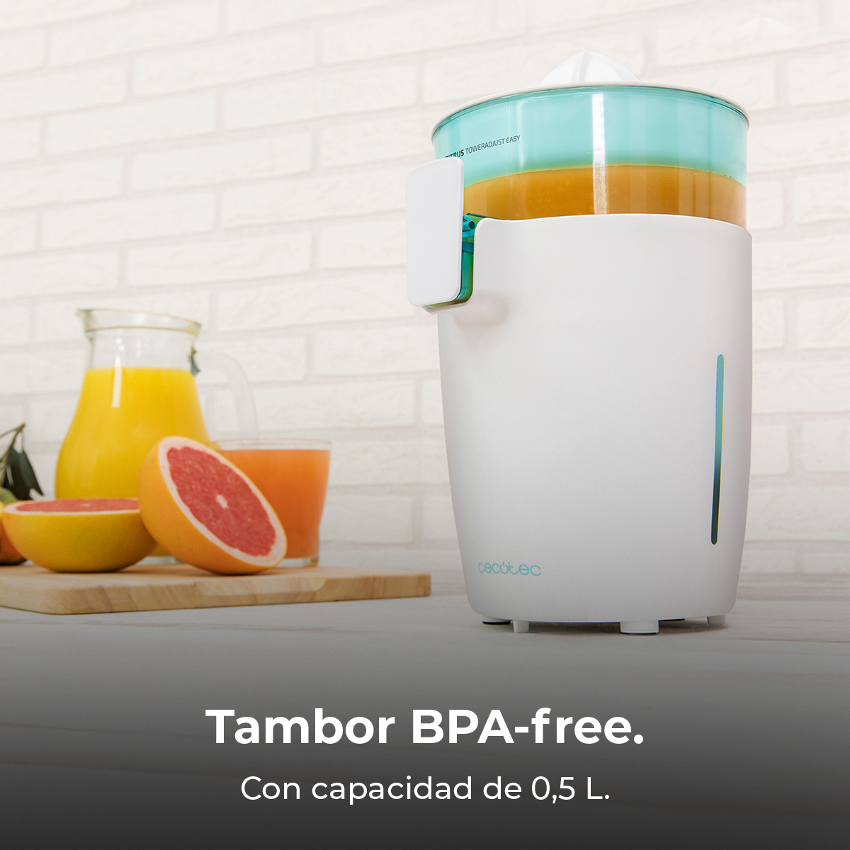 Spremiagrumi bianco con contenitore turchese, accanto a succo e pompelmi.