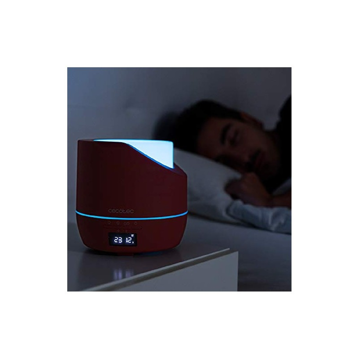 Czerwony nawilżacz z niebieskim światłem obok śpiącego mężczyzny.