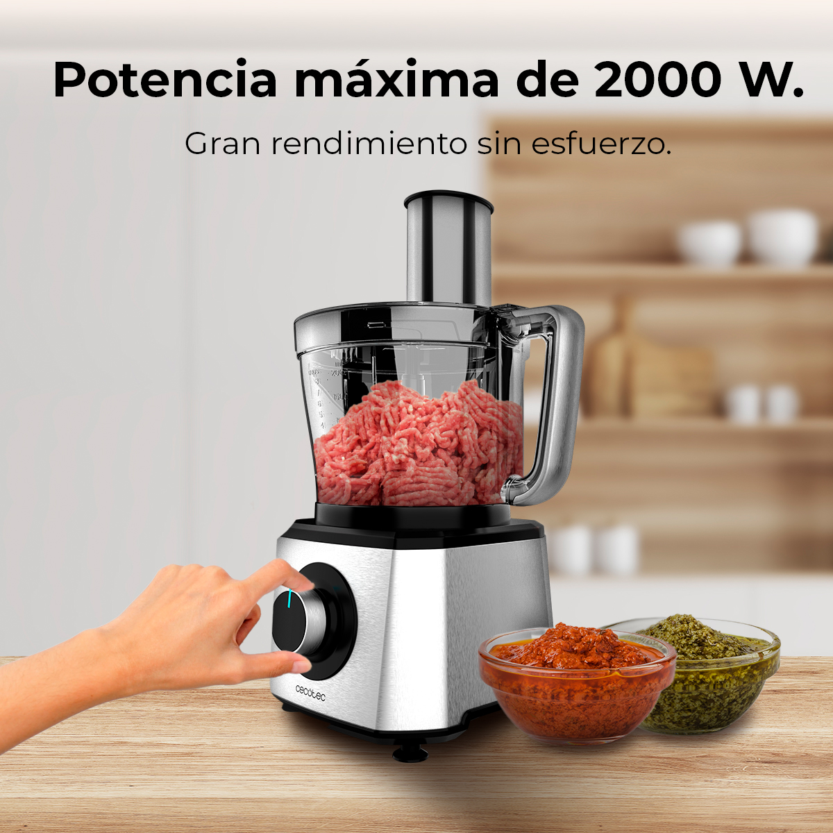 Robot da cucina con carne macinata, due ciotole di salse e una mano che aziona la manopola.