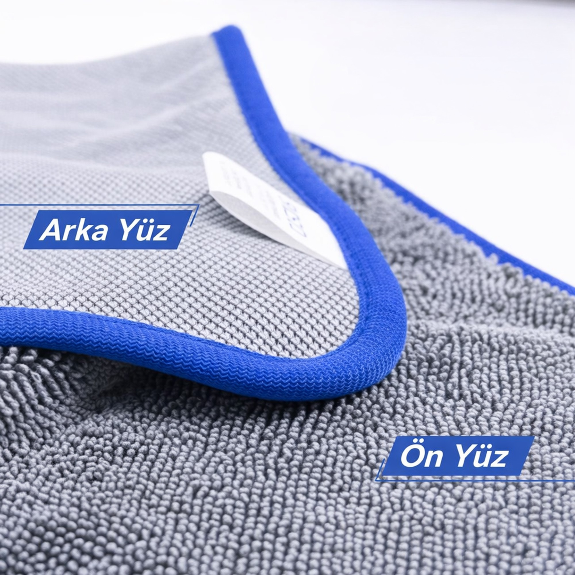 Mavi kenarlı gri mikrofiber havlu, ön ve arka yüzleri gösteriliyor.