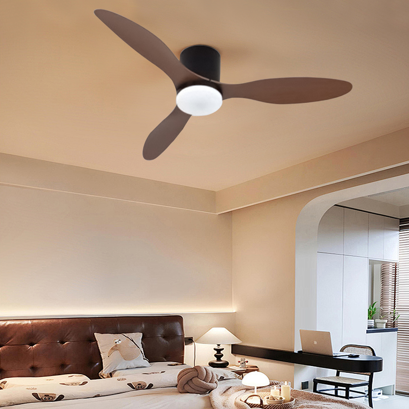 Un ventilador de techo con aspas marrones y una luz blanca cuelga sobre una cama.