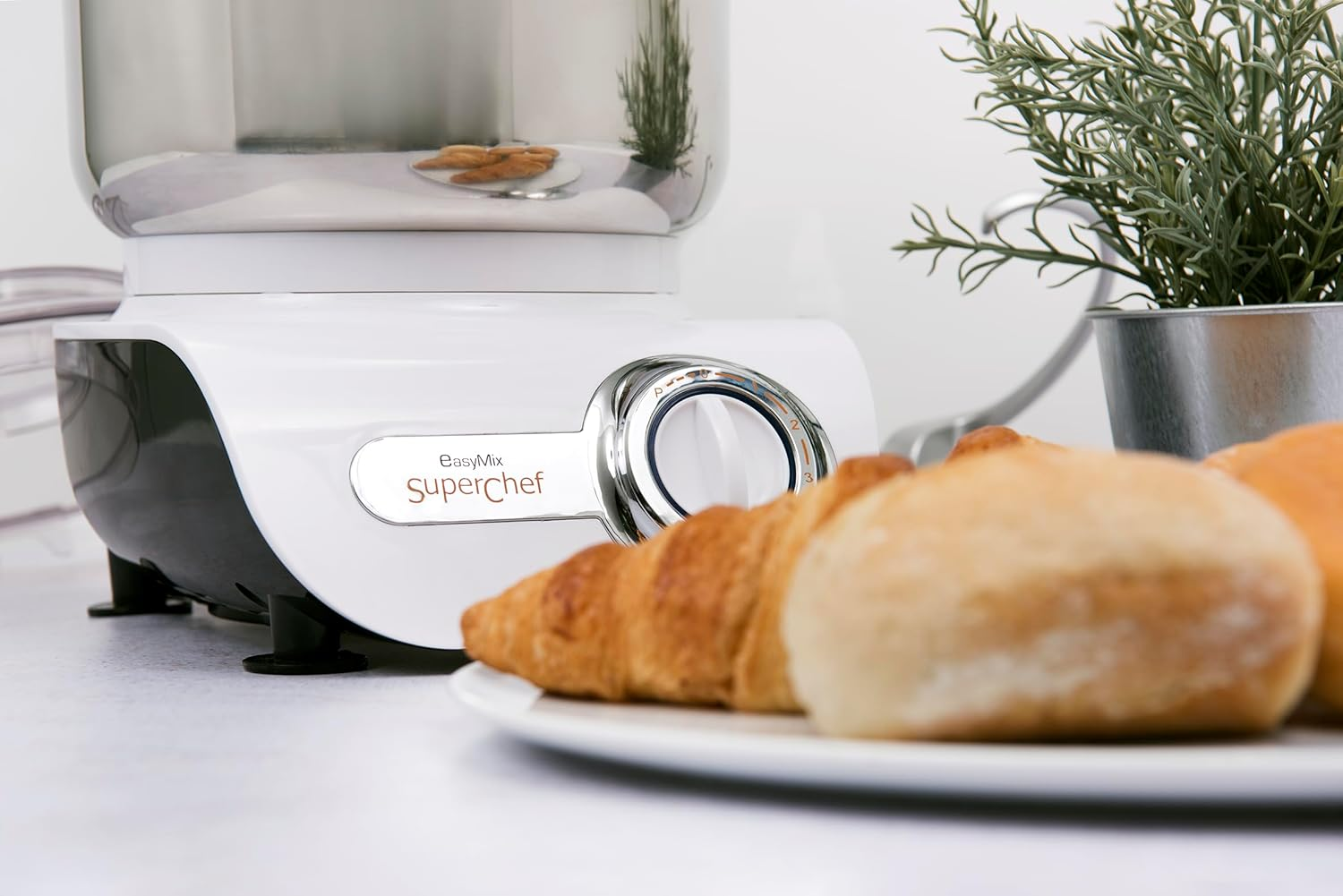 Impastatrice bianca con croissant e panini su un piatto.