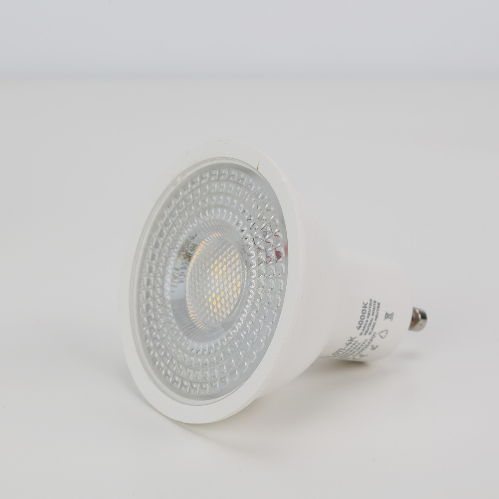 Una bombilla LED blanca con base GU10 sobre fondo blanco.