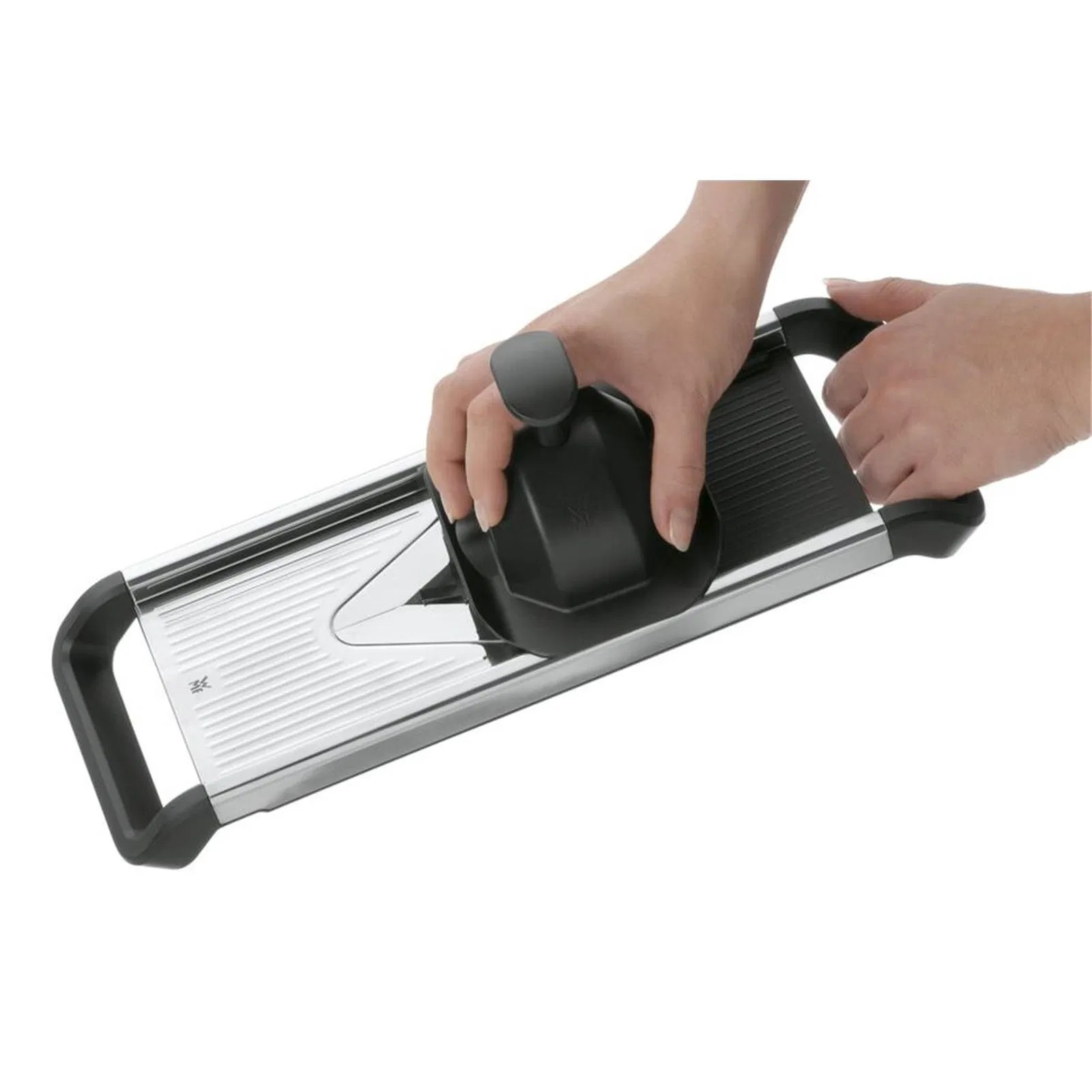 Dłonie używają mandoliny z uchwytem i ostrzem.