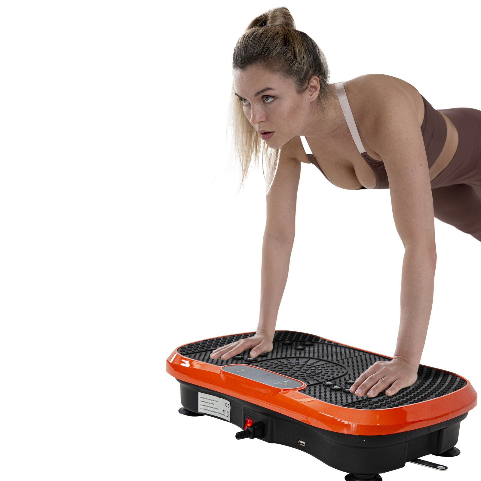 Mujer con ropa deportiva haciendo plancha sobre una placa vibratoria.