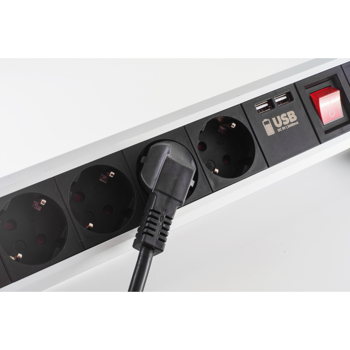 Ein Mehrfachsteckdosenleiste mit einem schwarzen Stecker in einer Steckdose.