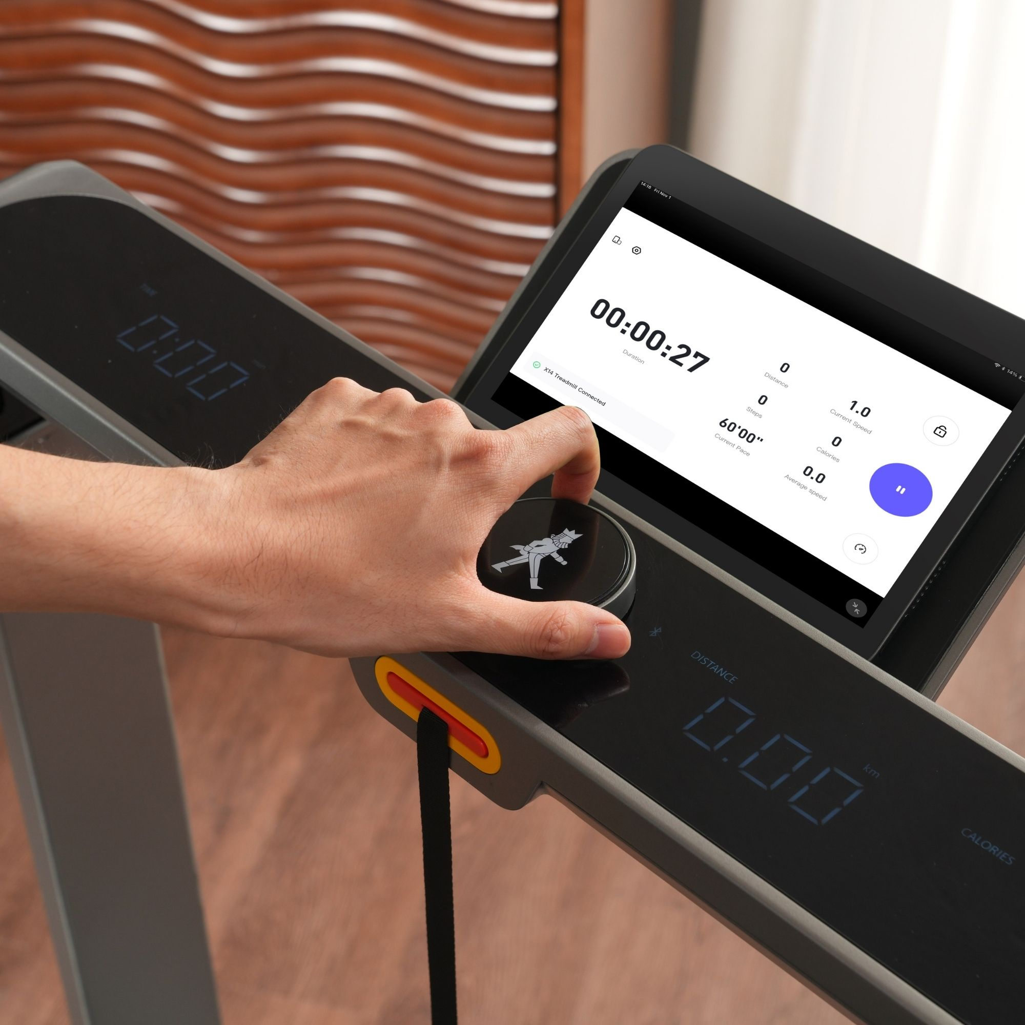 Mano operando cinta de correr con pantalla táctil, mostrando tiempo, distancia.
