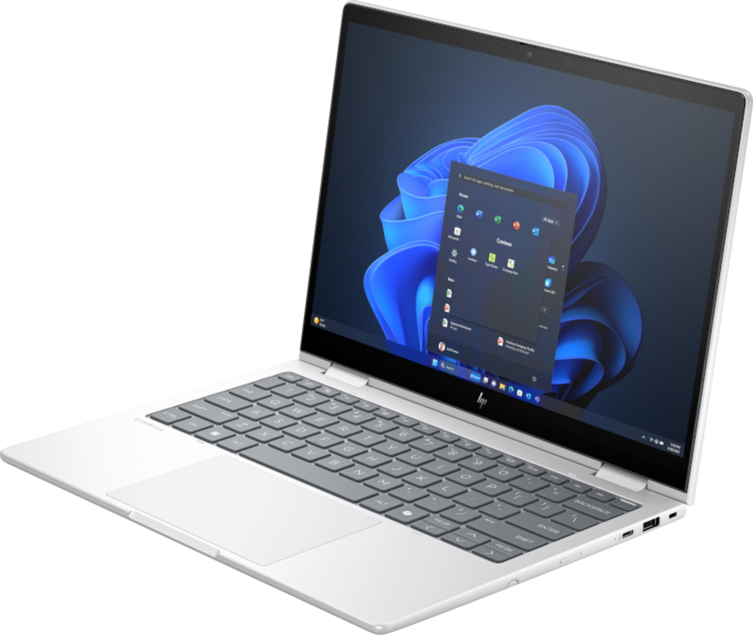 Un laptop argento con tastiera retroilluminata e sfondo blu.