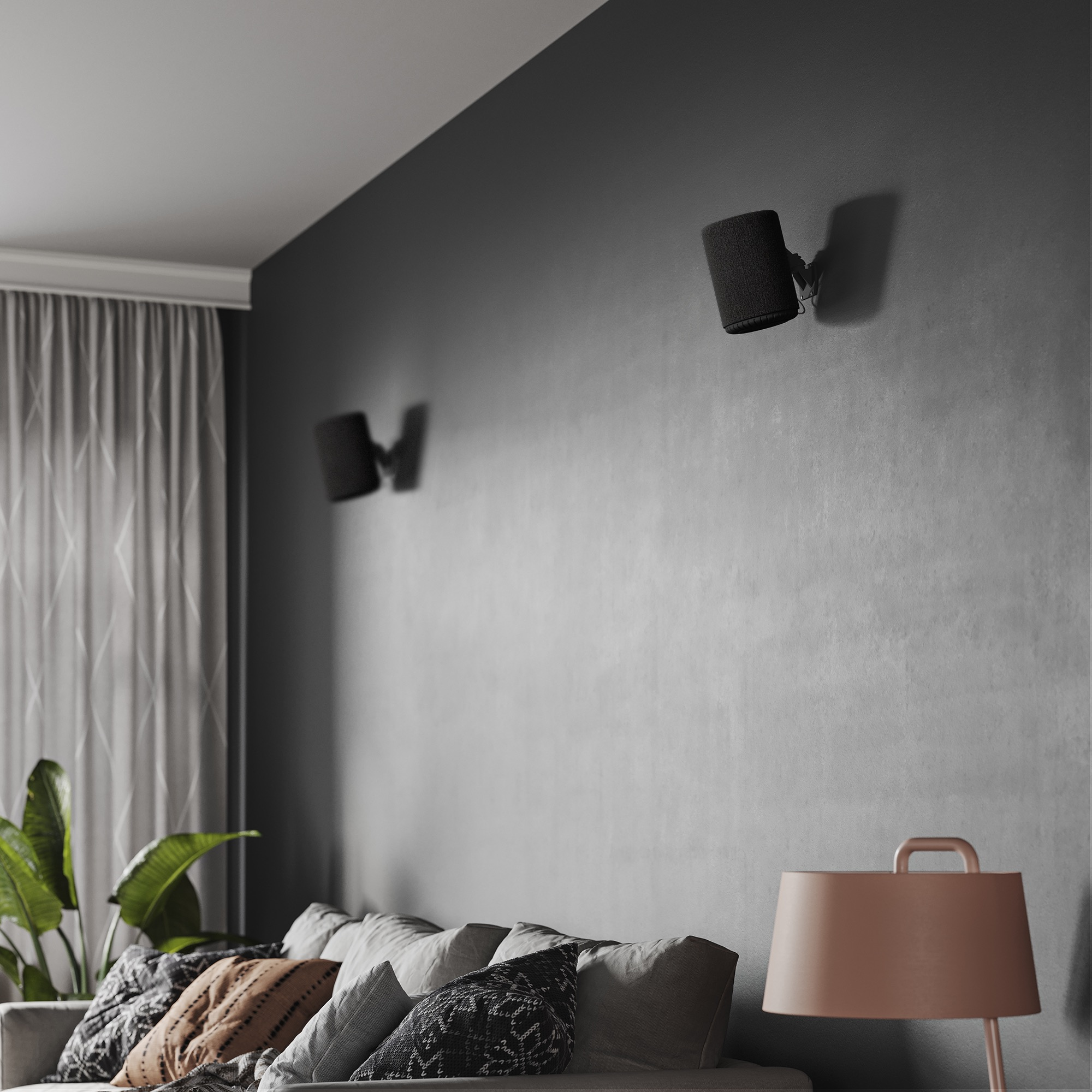 Een woonkamer met een bank, lamp en twee luidsprekers aan de muur.