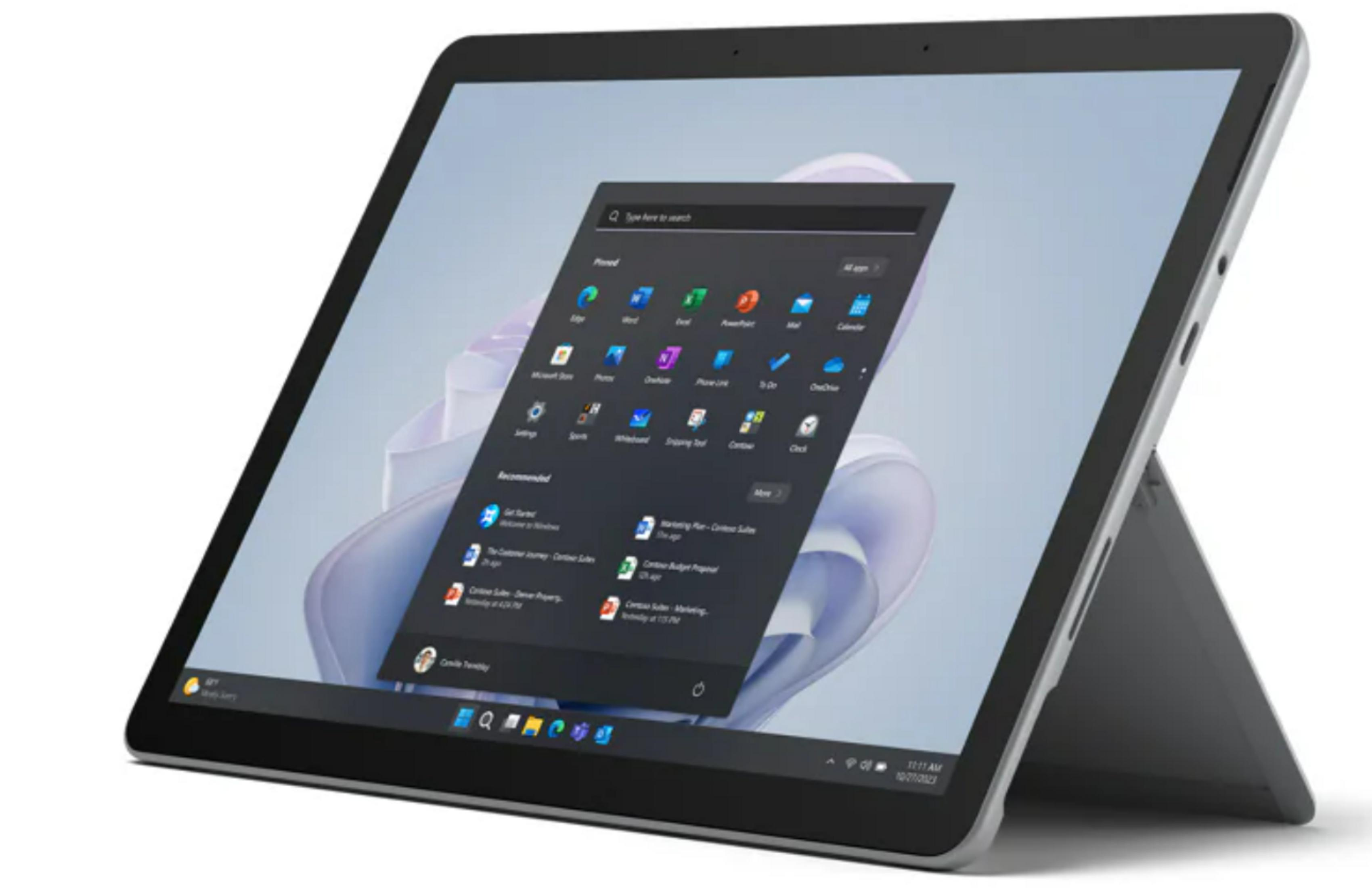 Srebrny tablet wyświetlający menu Start systemu Windows z otwartymi aplikacjami. Podstawka jest rozłożona.