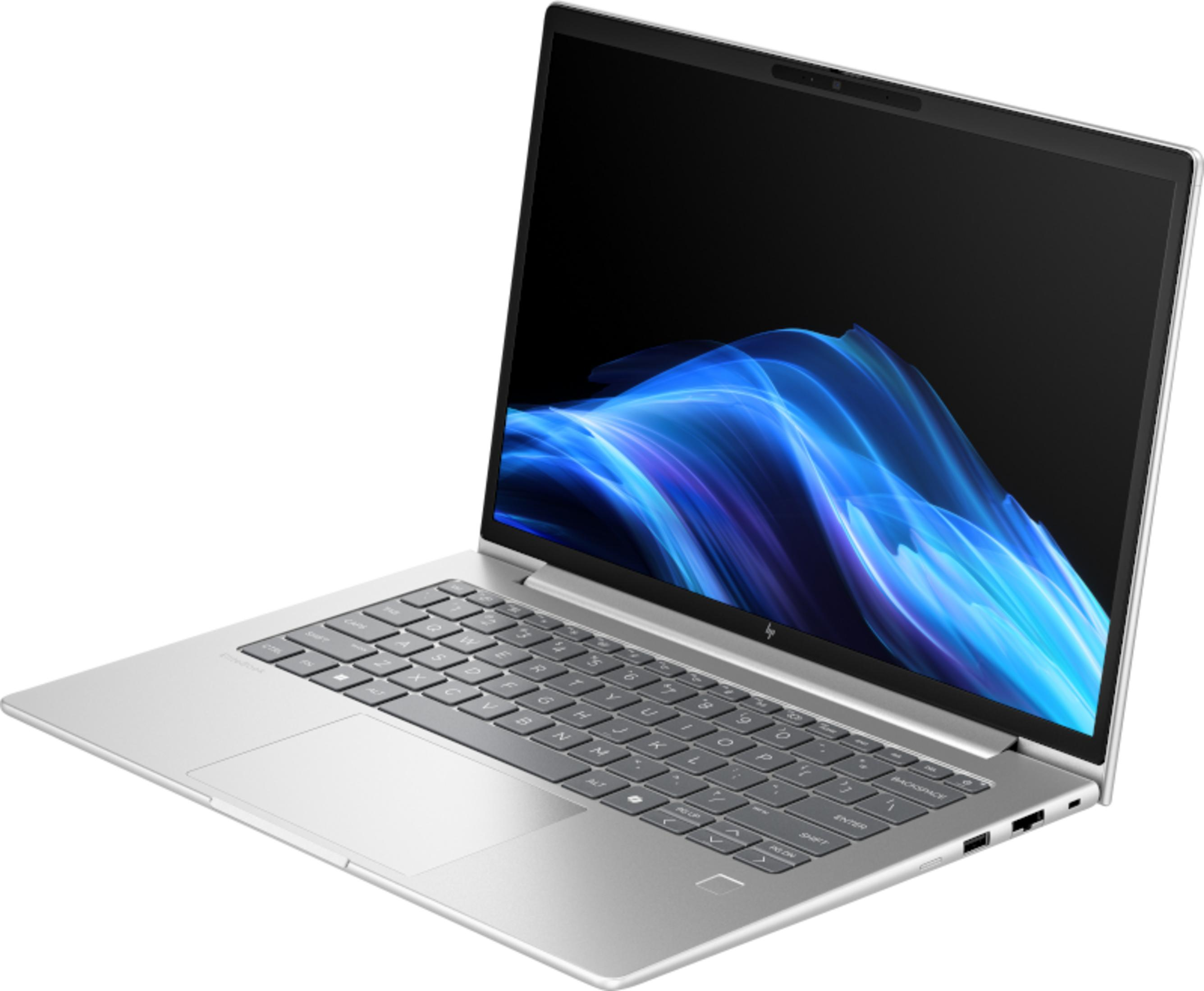 Srebrny laptop z niebieskim, falistym obrazem tła na ekranie.