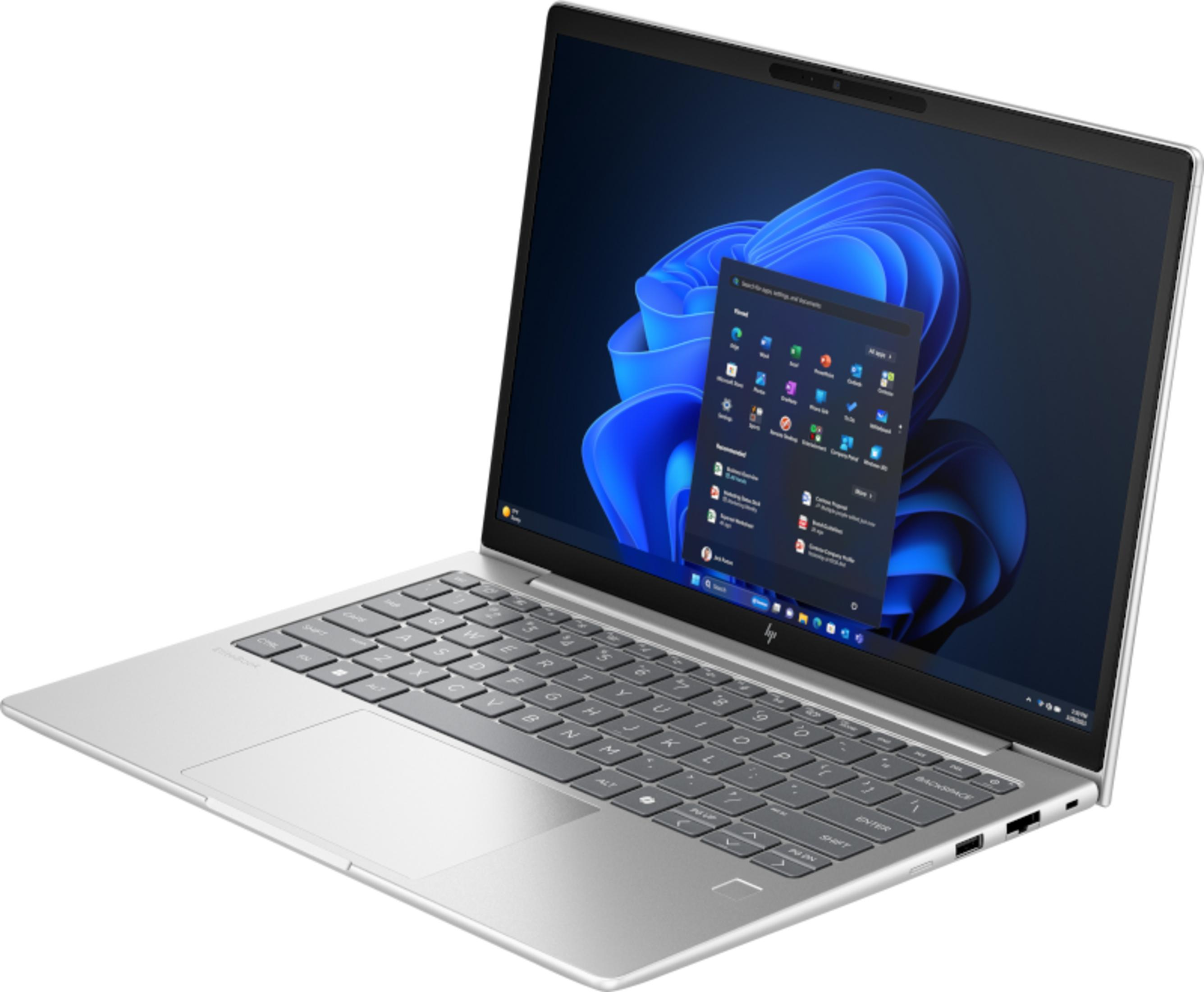 Un laptop argentato con lo schermo aperto, che mostra il menu Start di Windows 11.