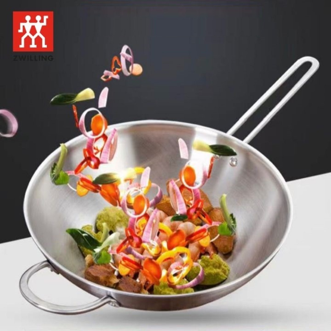 Gemüse fliegt in eine Pfanne. ZWILLING-Logo oben links.