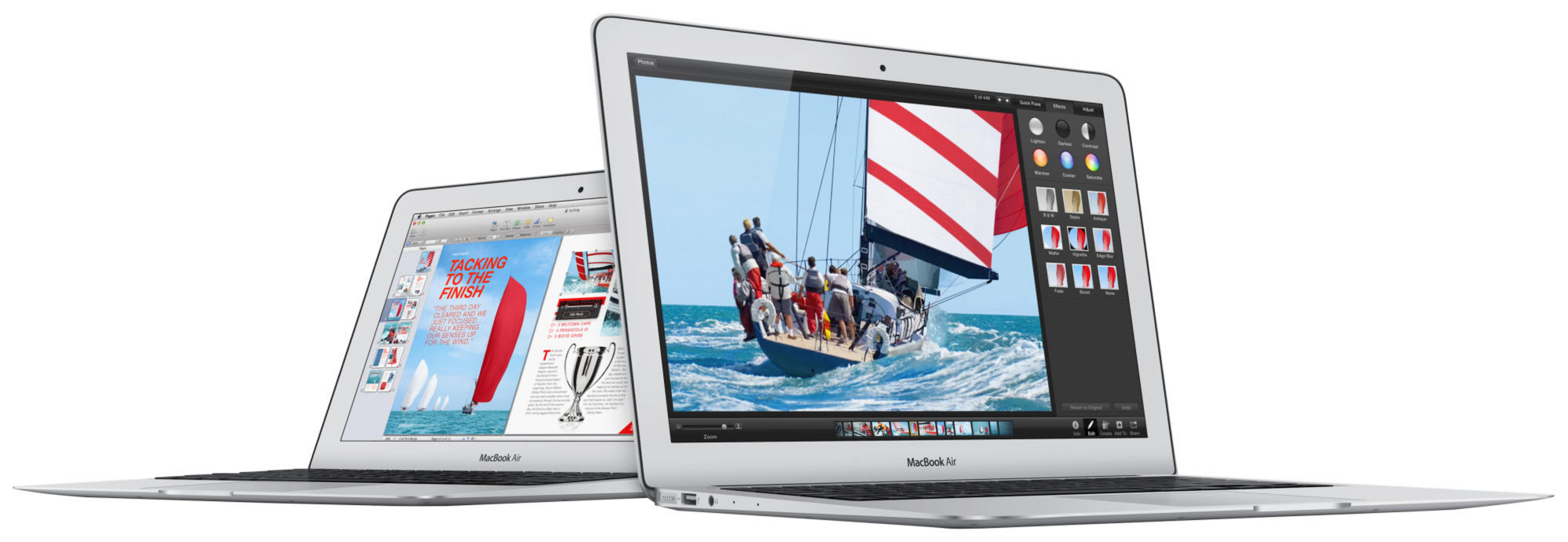 Zwei silberne Laptops nebeneinander. Einer zeigt ein Segelboot auf dem Wasser, der andere eine Zeitschrift.