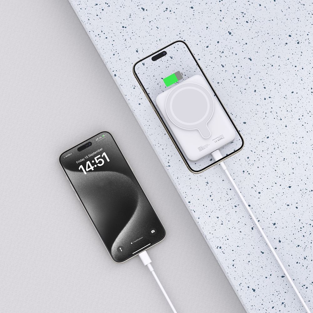 Zwei iPhones, eines lädt mit weißem MagSafe-Ladegerät, das andere ist verbunden.