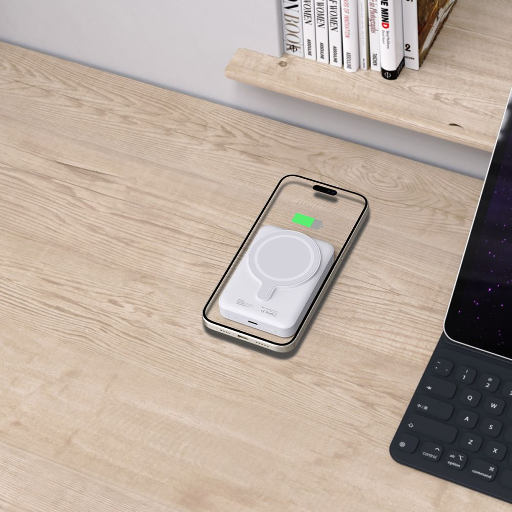 Ein weißes Handy-Ladegerät auf einem Handy auf einem Holztisch.