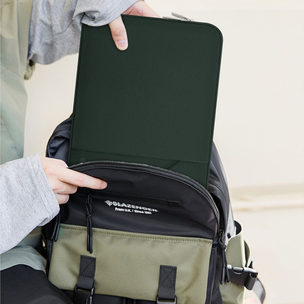 Eine Person steckt eine dunkelgrüne Hülle in einen Rucksack.
