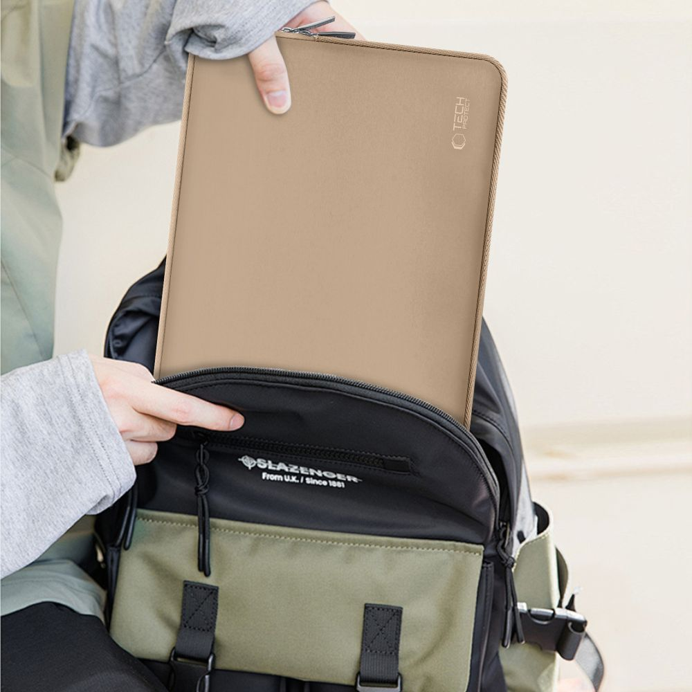 Eine Person steckt eine beige Laptoptasche in einen Rucksack.