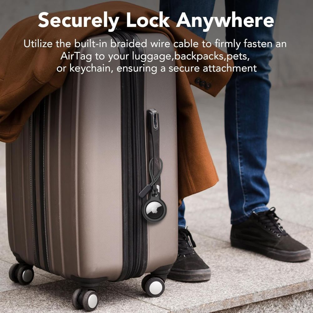 Ein grauer Koffer mit einem schwarzen AirTag-Tracker, der an einer Schlaufe befestigt ist.