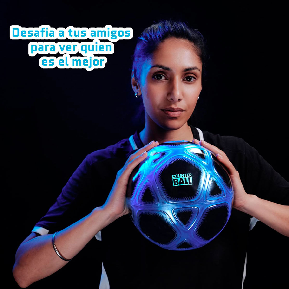 Una donna tiene un pallone da calcio luminoso con luci blu e viola su sfondo scuro.