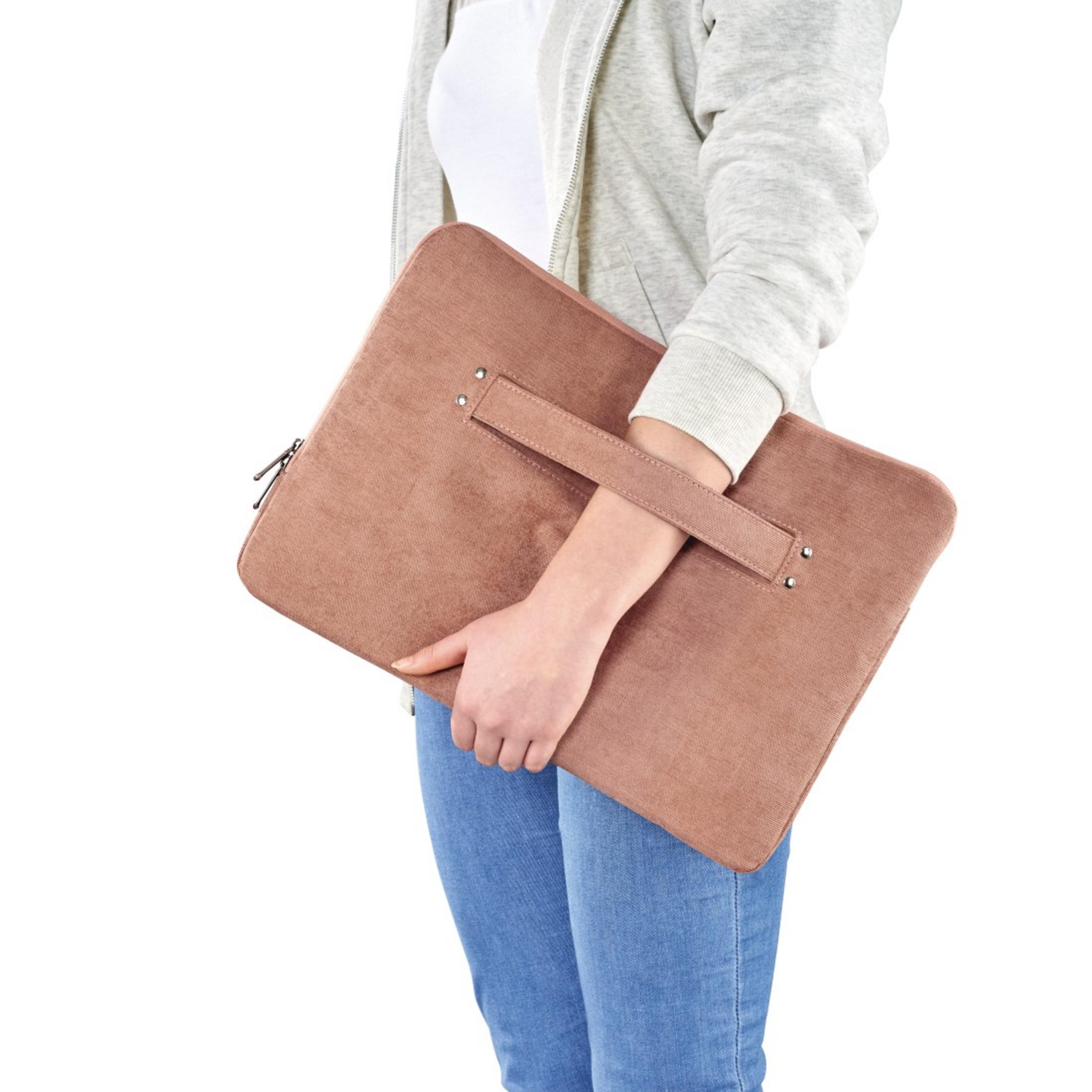 Osoba trzyma brązową torbę na laptopa z uchwytem.