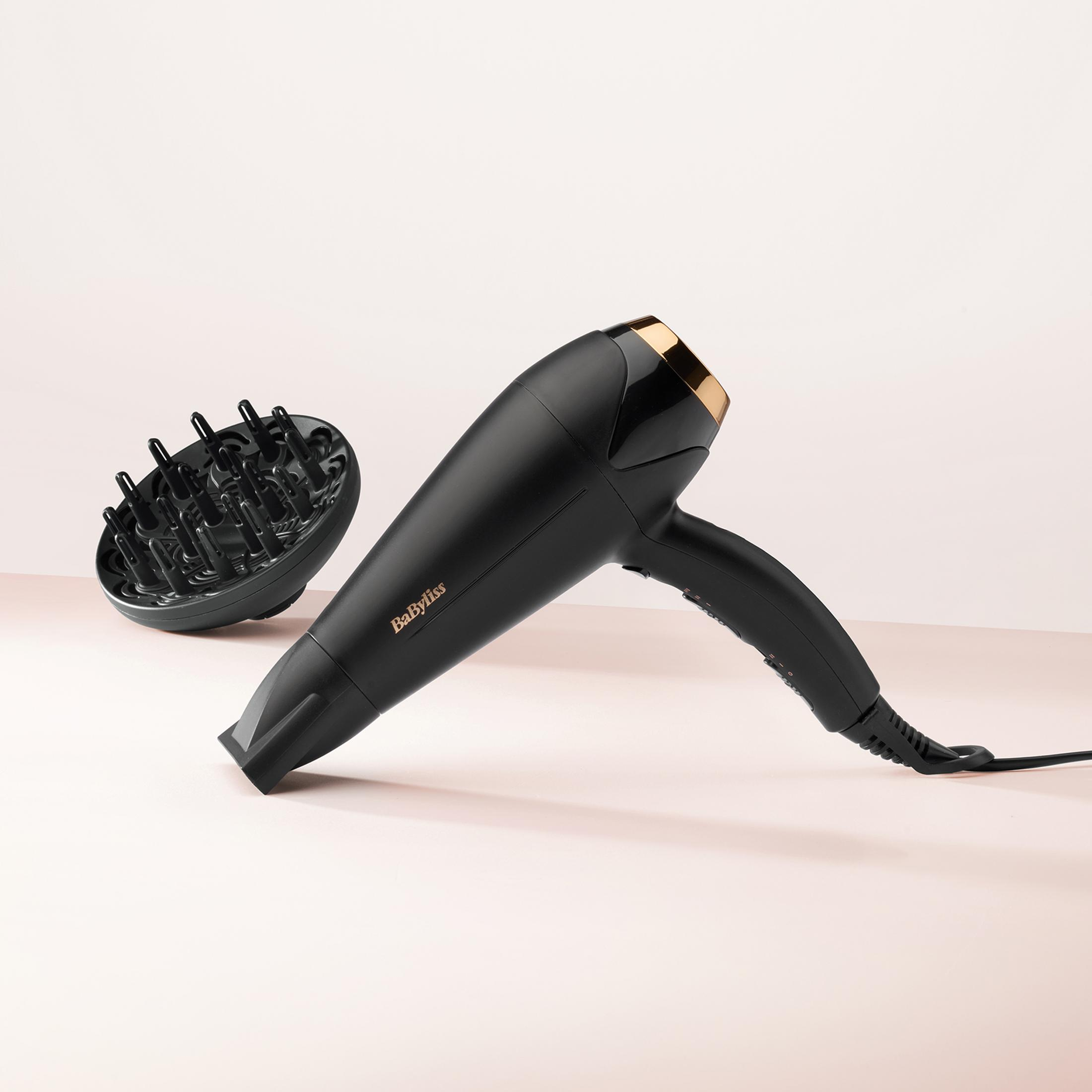 Un secador de pelo negro con difusor y detalles dorados.