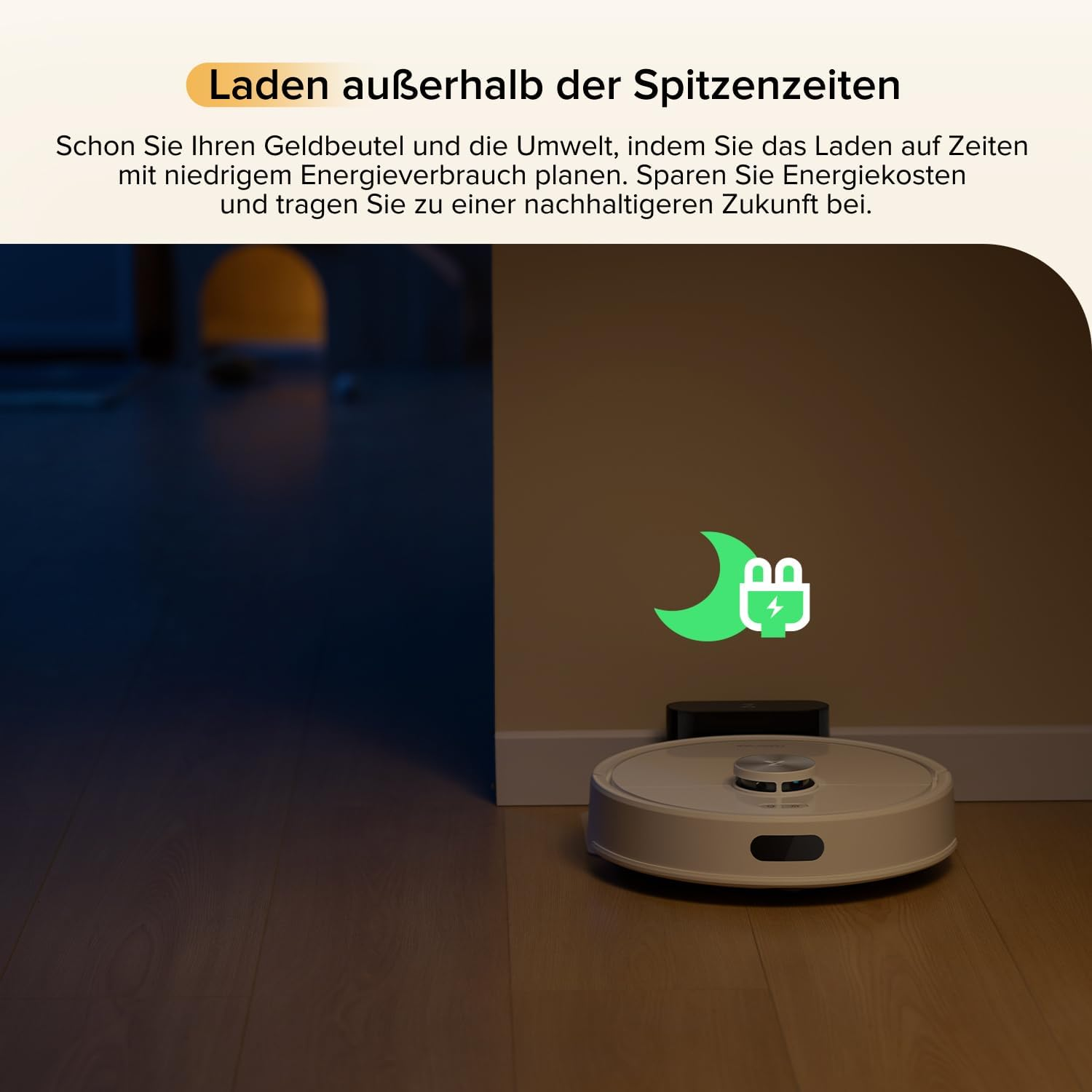 Ein weißer Saugroboter lädt an seiner Ladestation. Ein grünes Symbol zeigt eine Mondsichel und ein Stecker an.