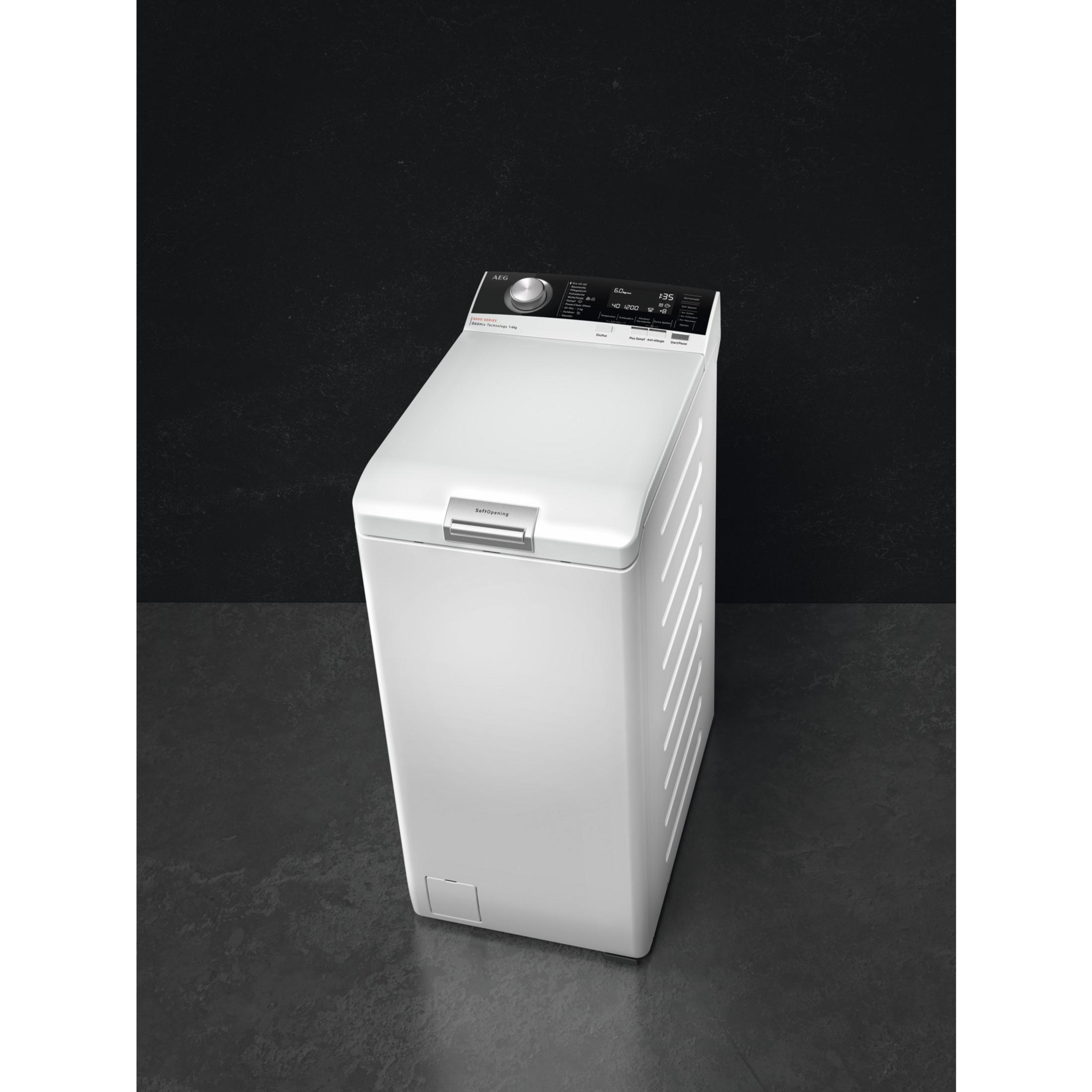Une machine à laver AEG blanche avec écran numérique se tient sur un sol sombre.