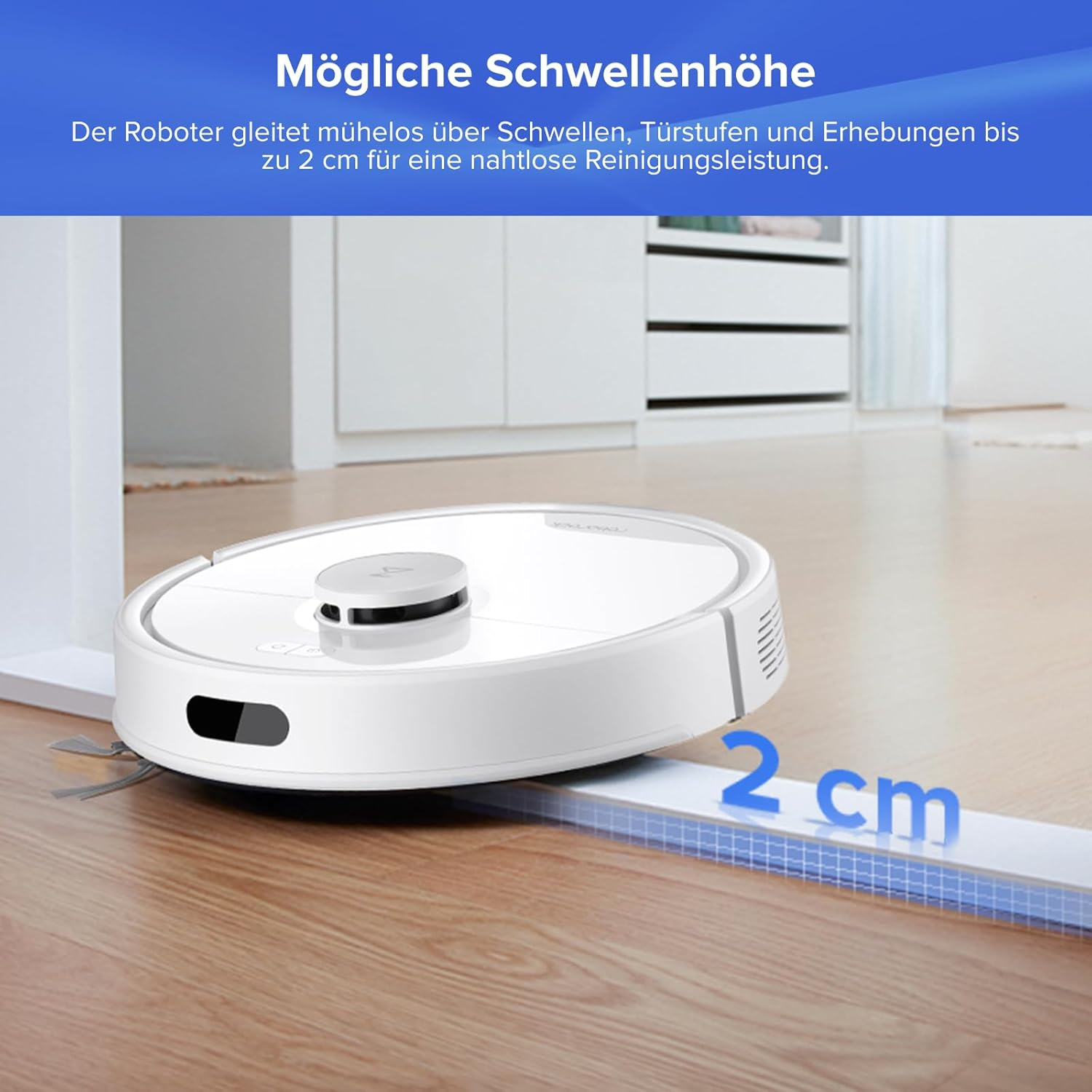 Weißer Saugroboter überquert eine 2 cm hohe Schwelle auf Holzboden.