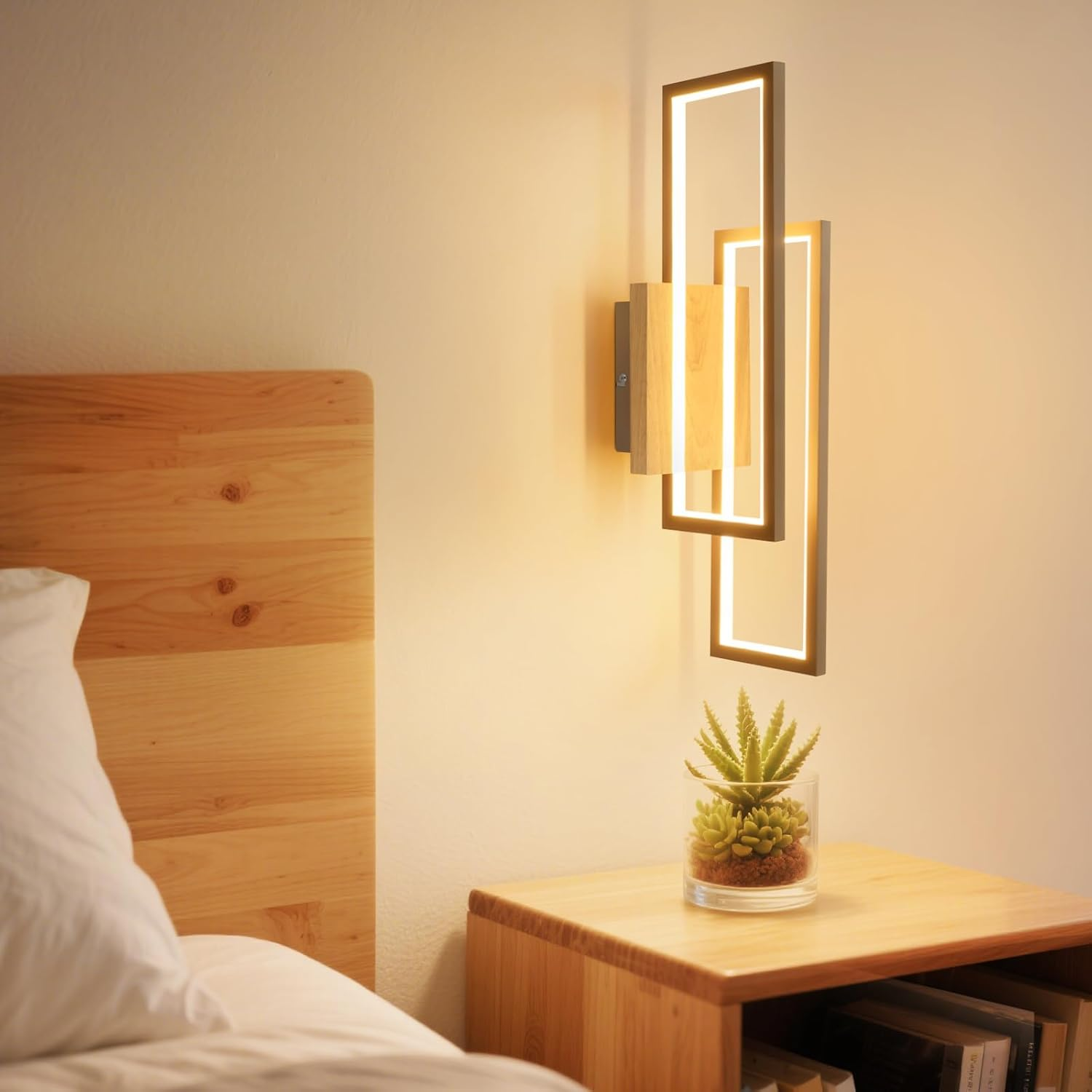 Lampada da parete moderna con cornici geometriche illumina comodino con pianta.