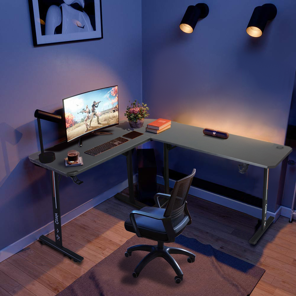 Biurko narożne z monitorem, klawiaturą, krzesłem i dwiema lampami.