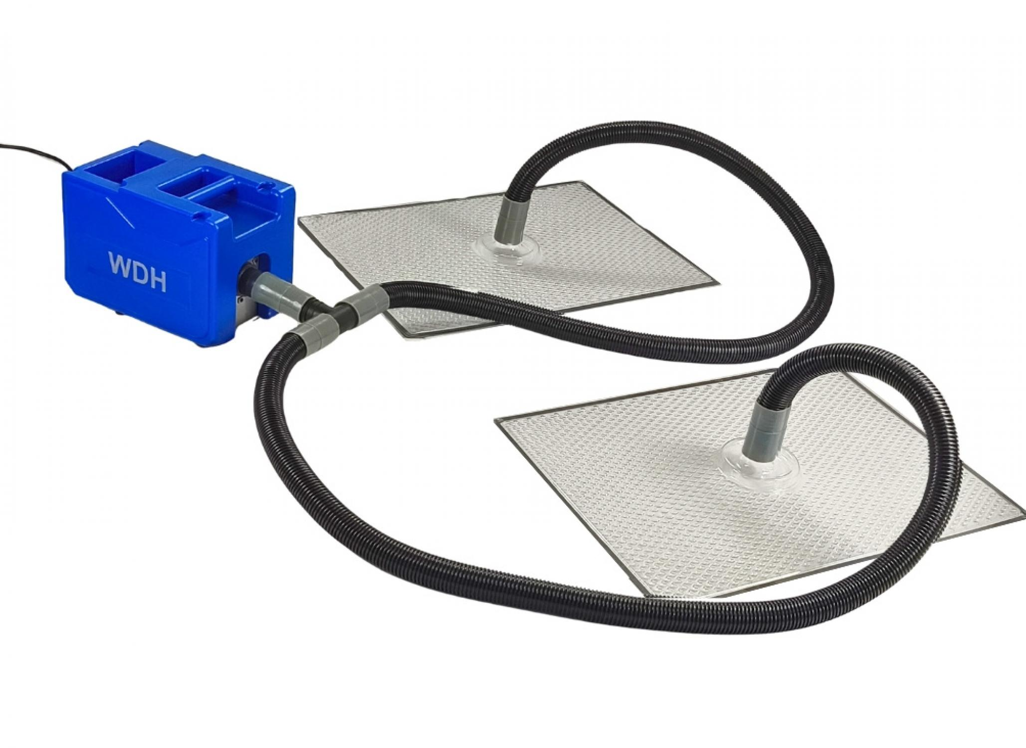 Ein blaues WDH-Gerät mit zwei Schläuchen, die an flache, metallische Platten angeschlossen sind.