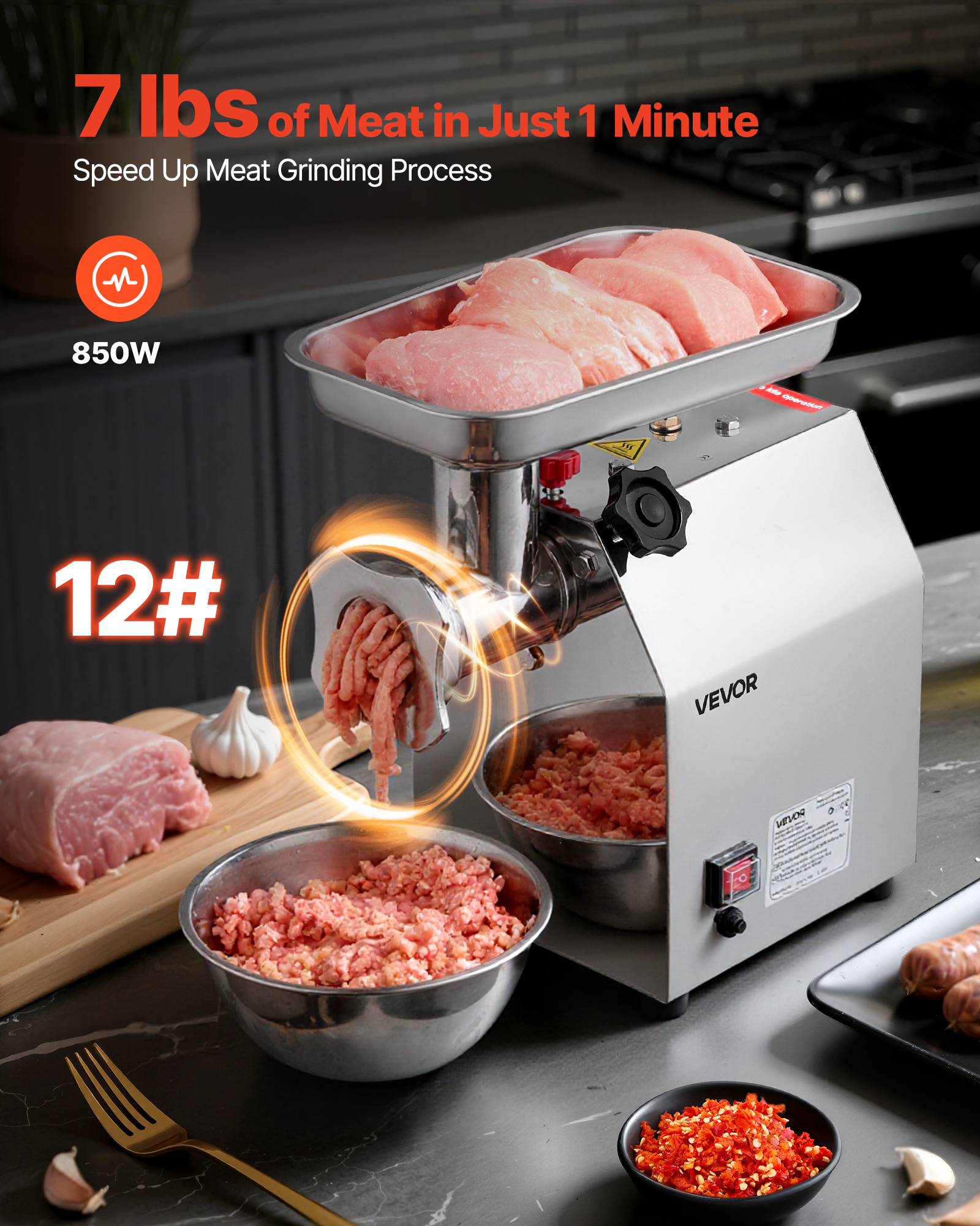 Un picador de carne plateado procesa carne cruda. Ingredientes como ajo, un tenedor y chile están cerca.