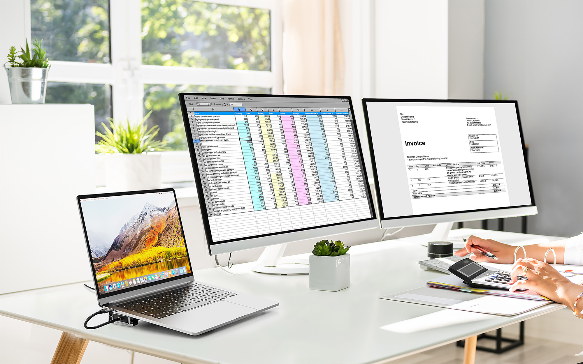 Büro mit drei Bildschirmen, Laptop, Rechner und Pflanzen. Tabellen und Rechnungen werden angezeigt.