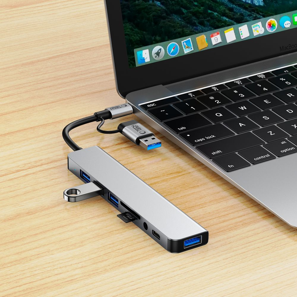 Un hub USB argentato con più porte è collegato a un laptop.