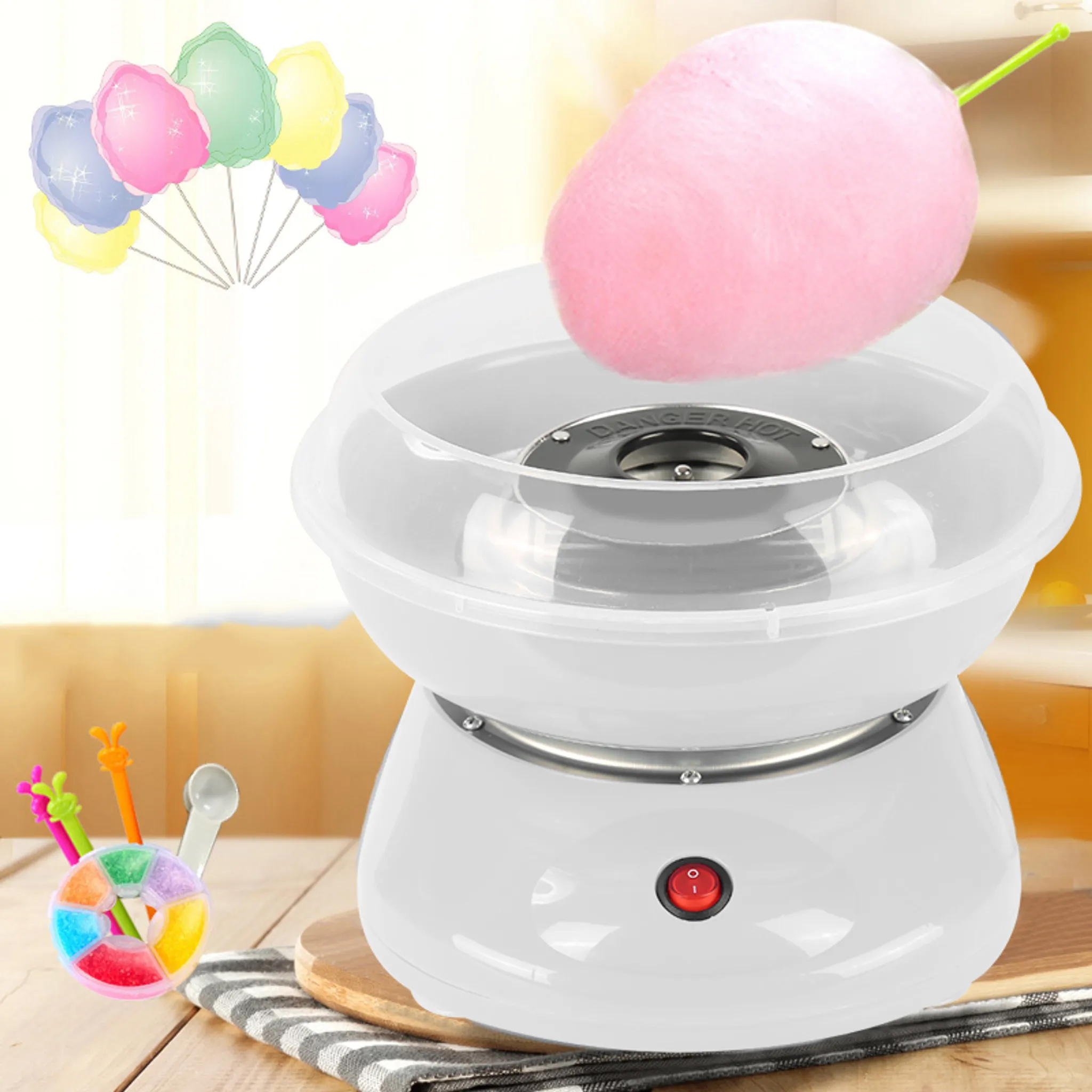 Eine weiße Zuckerwatte-Maschine mit rosa Zuckerwatte und bunten Zuckerwatte-Portionen.