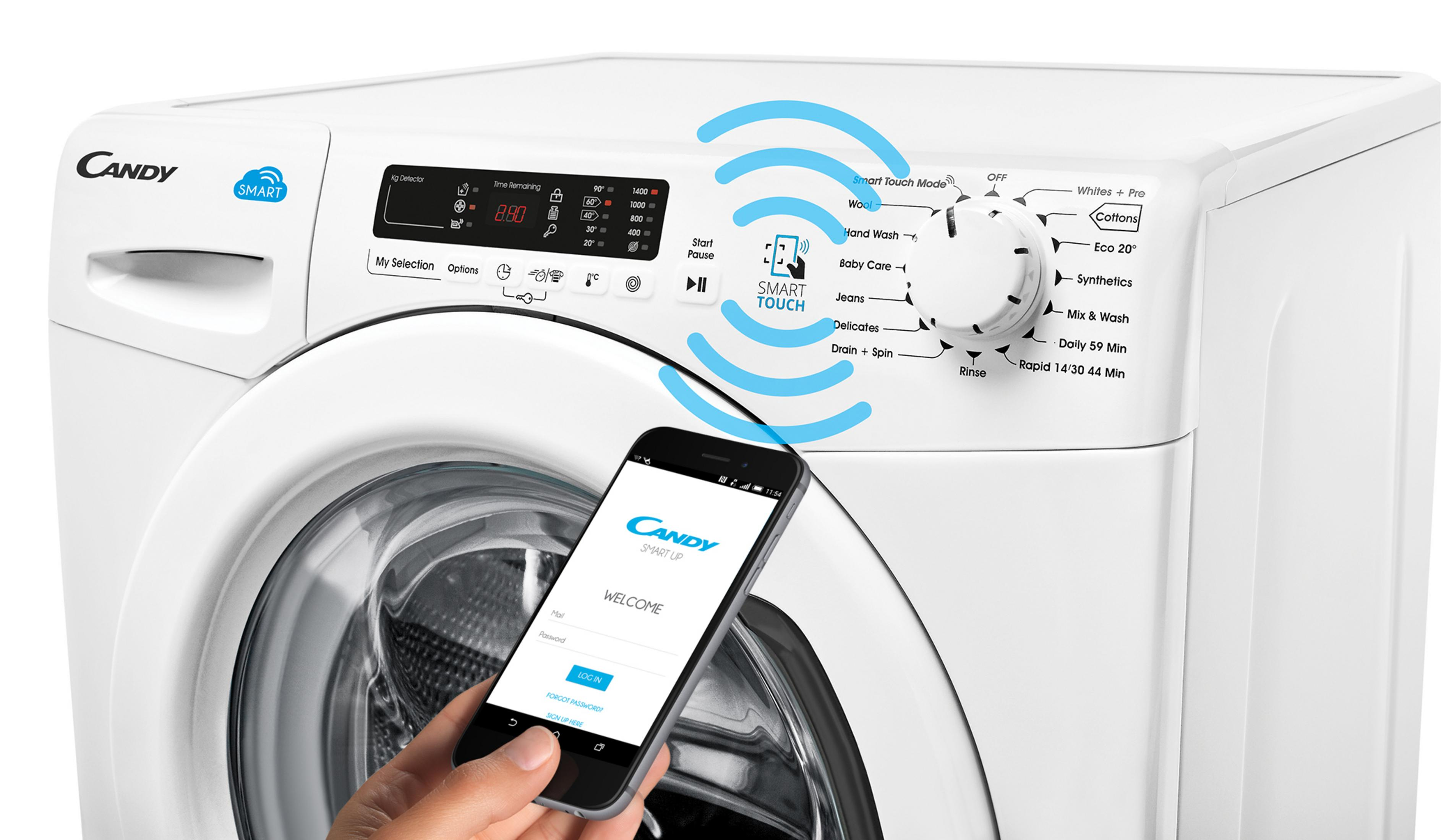 Una mano tiene uno smartphone con l'app Candy Smart Up davanti a una lavatrice Candy.