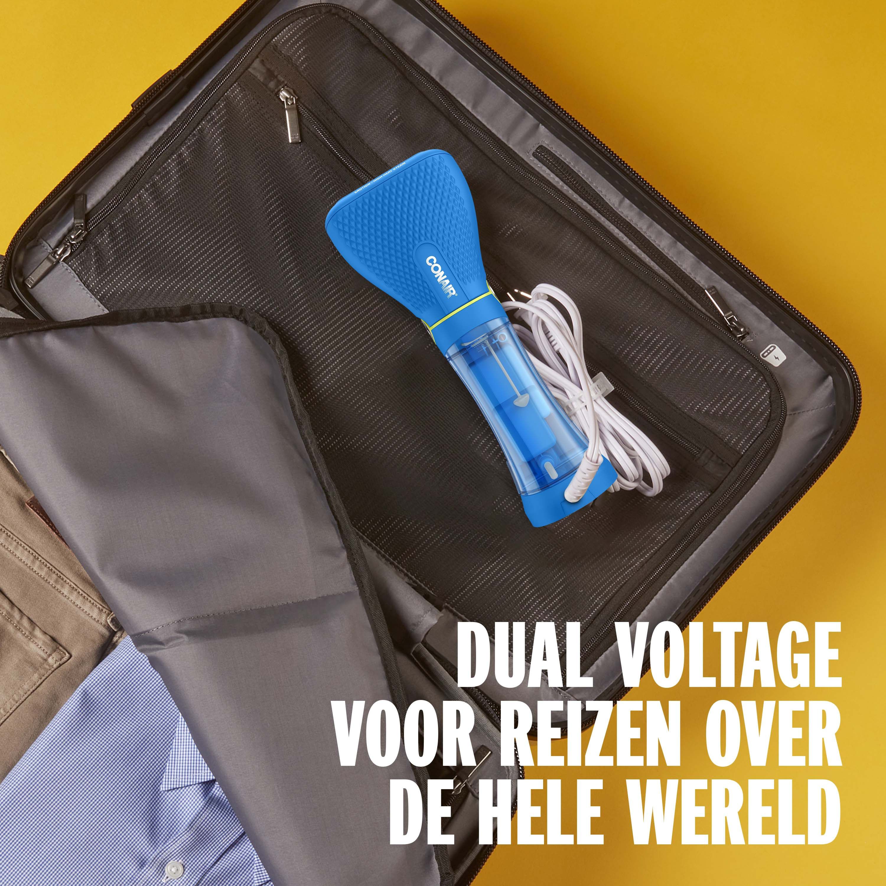 A blue travel steamer lies in an open suitcase next to clothes.