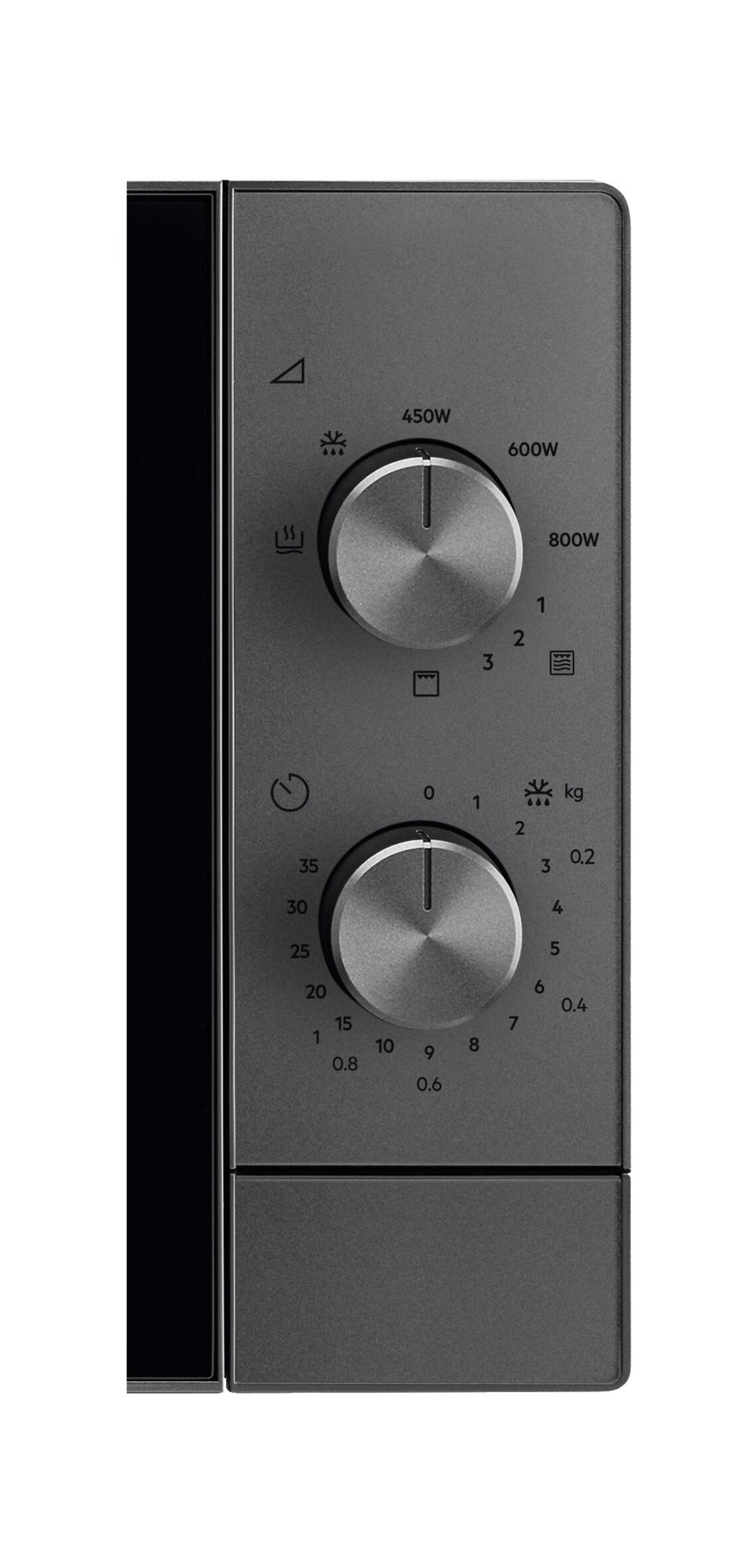 Zbliżenie dwóch pokręteł i symboli na ciemnym panelu sterowania.