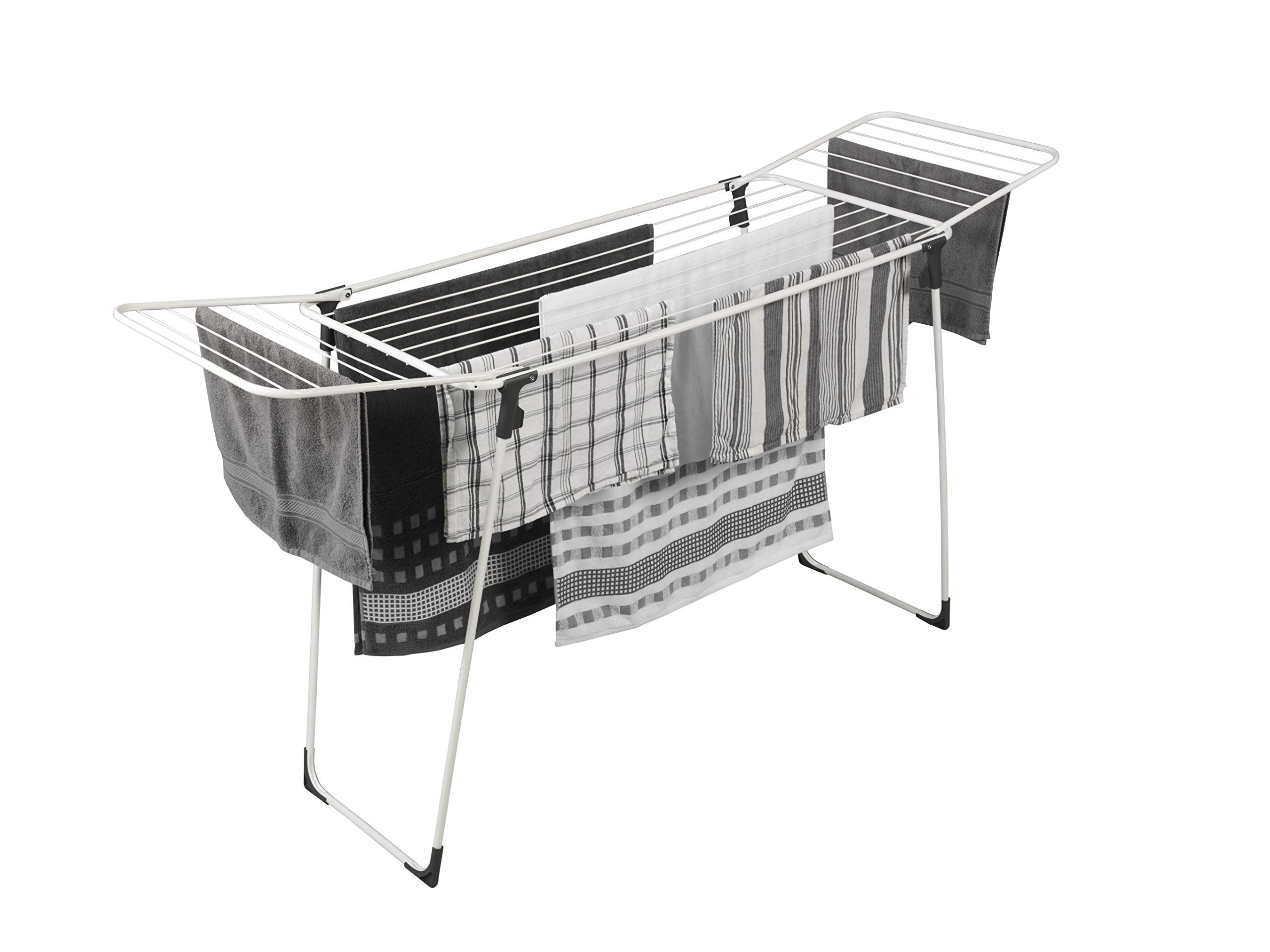 A white clothes drying rack with various towels and linens.