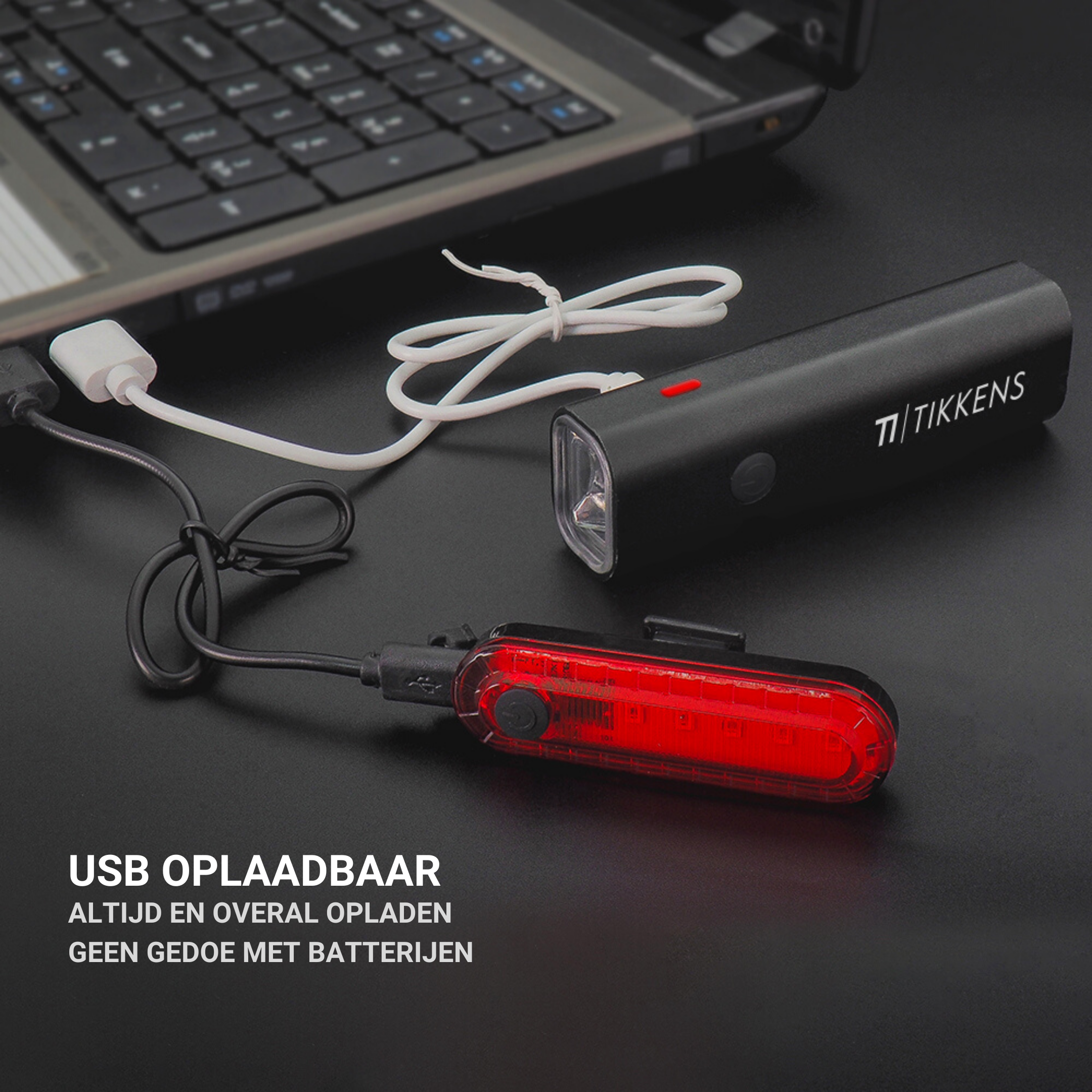 A black bicycle headlight and taillight are connected to a laptop.