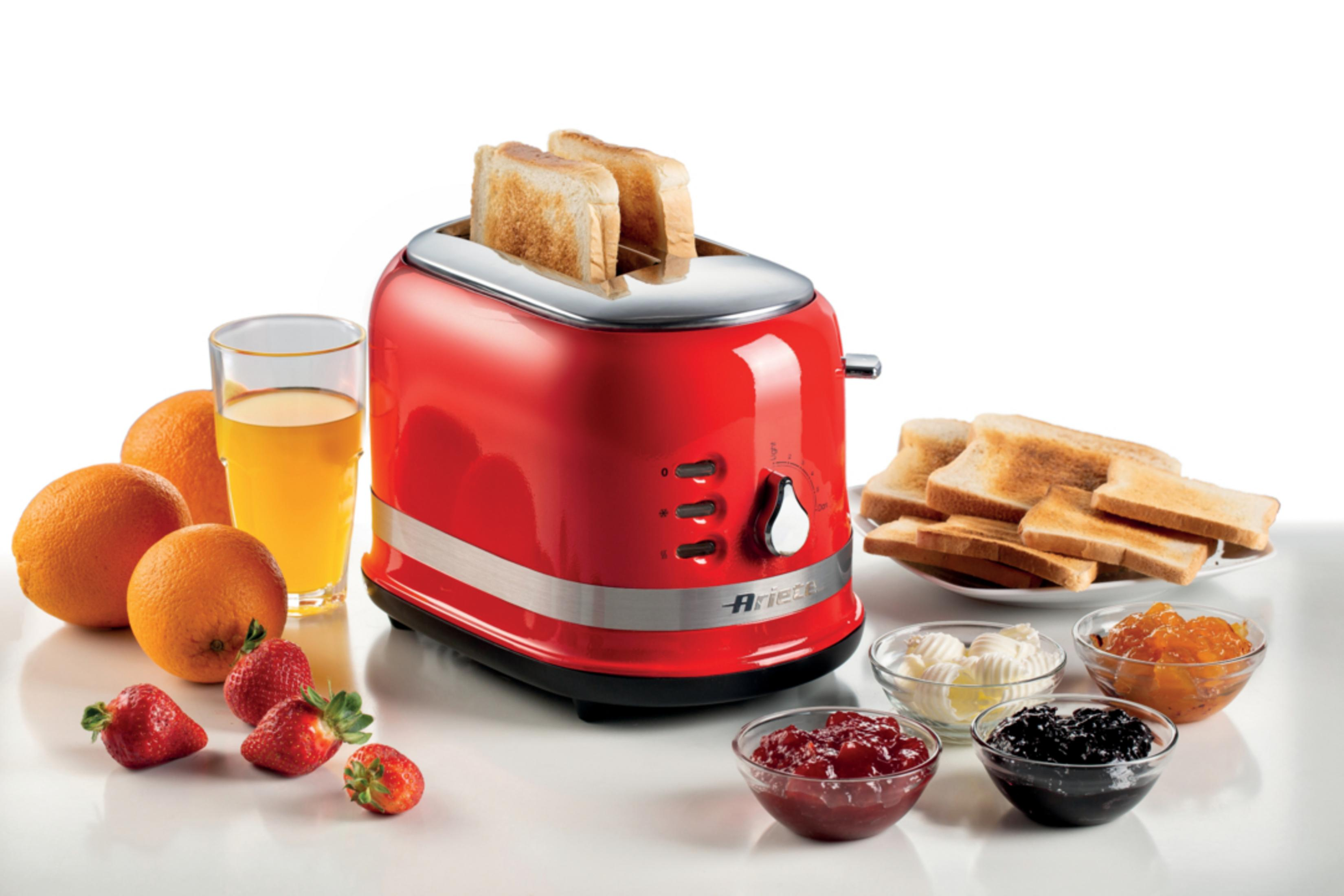 Czerwony toster z tostami, pomarańczami, jagodami, sokiem i dżemami.