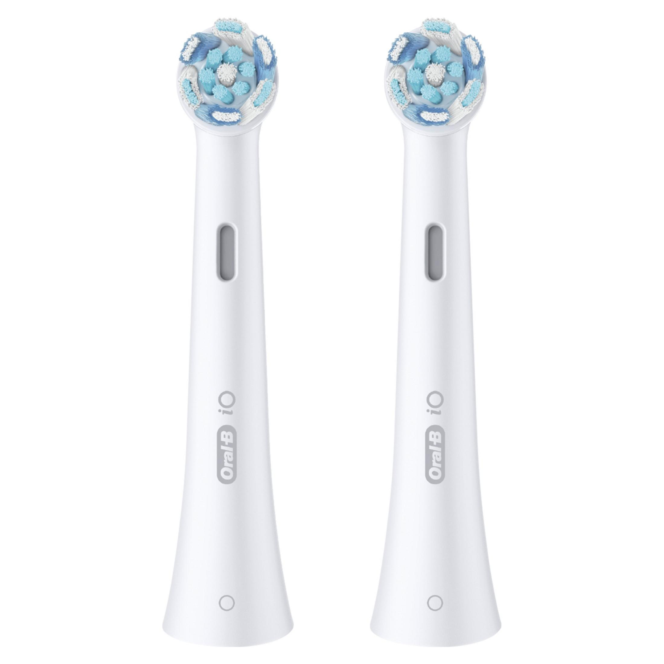 Dwie białe główki szczoteczki do zębów z niebieskimi i białymi włoskami obok siebie.