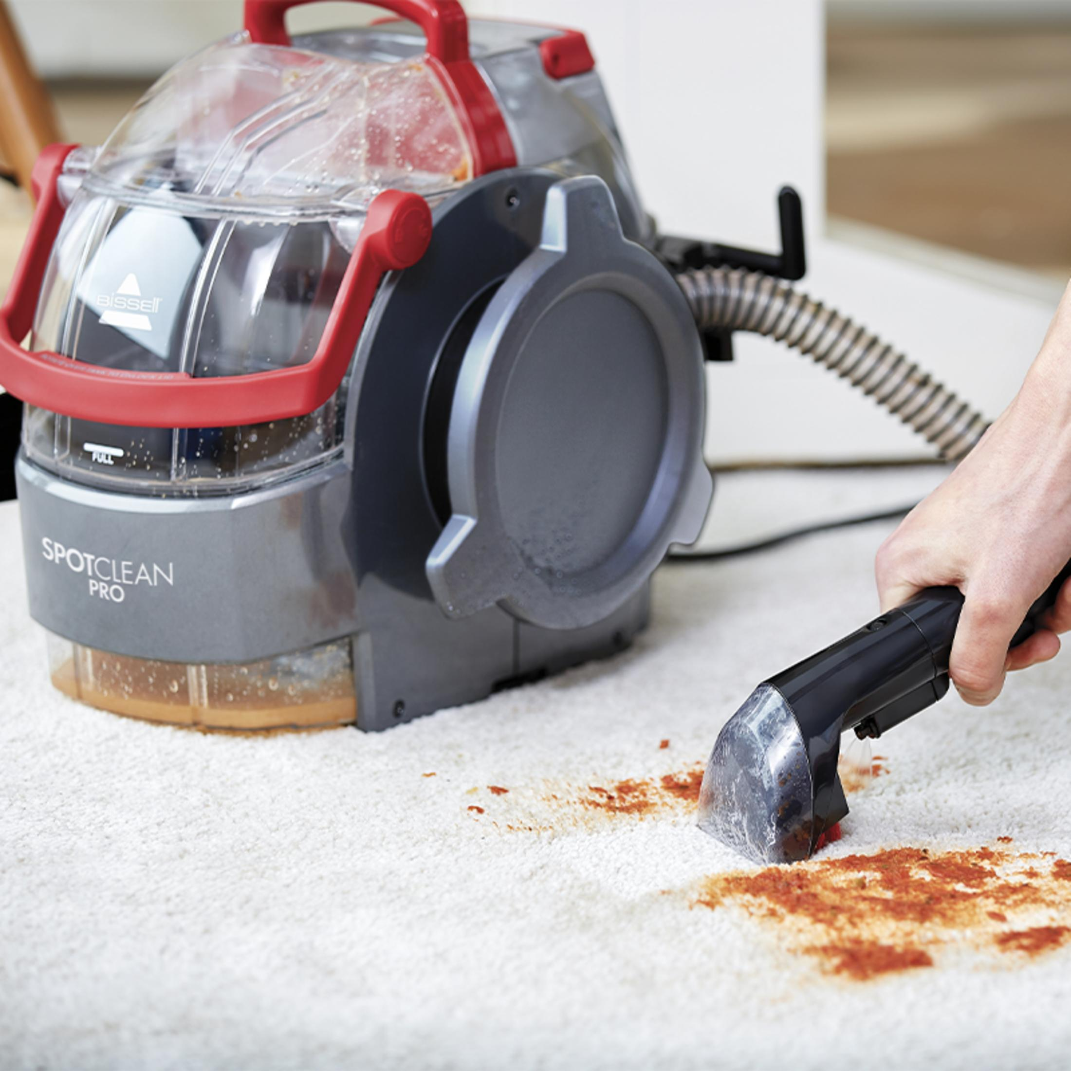 Bissell SpotClean Pro czyści czerwone plamy na białym dywanie.