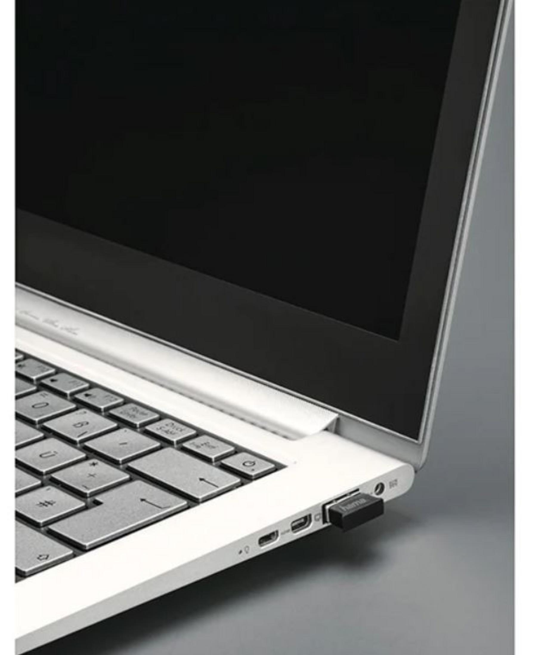 Laptop z podłączonym czarnym kluczem USB z boku.