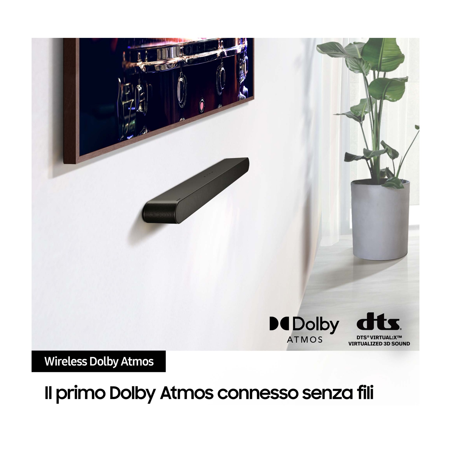 Czarny soundbar wisi na białej ścianie pod telewizorem wyświetlającym obraz bębna.