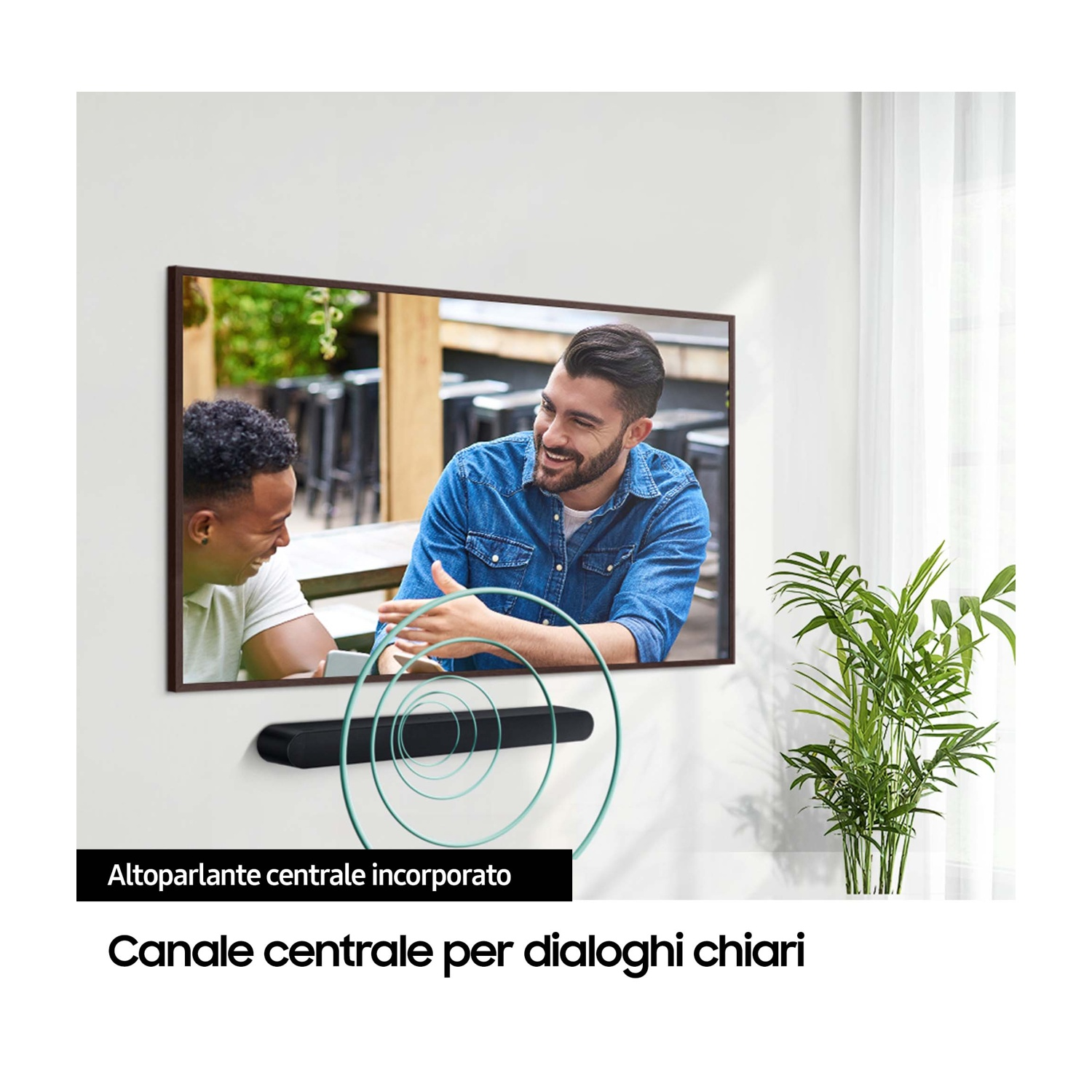 Mężczyzna w dżinsowej koszuli śmieje się na ekranie. Poniżej soundbar.