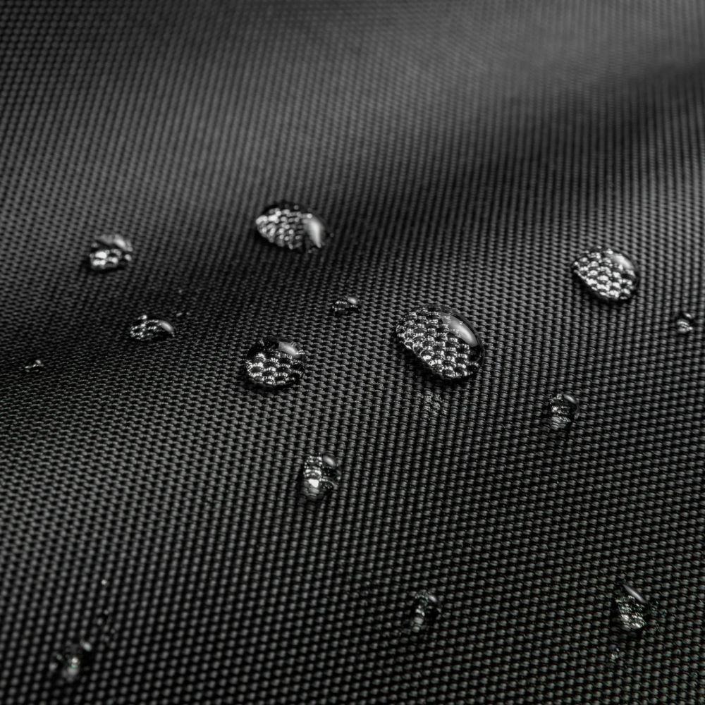 Wassertropfen auf schwarzem, texturiertem Stoff. Nahaufnahme.