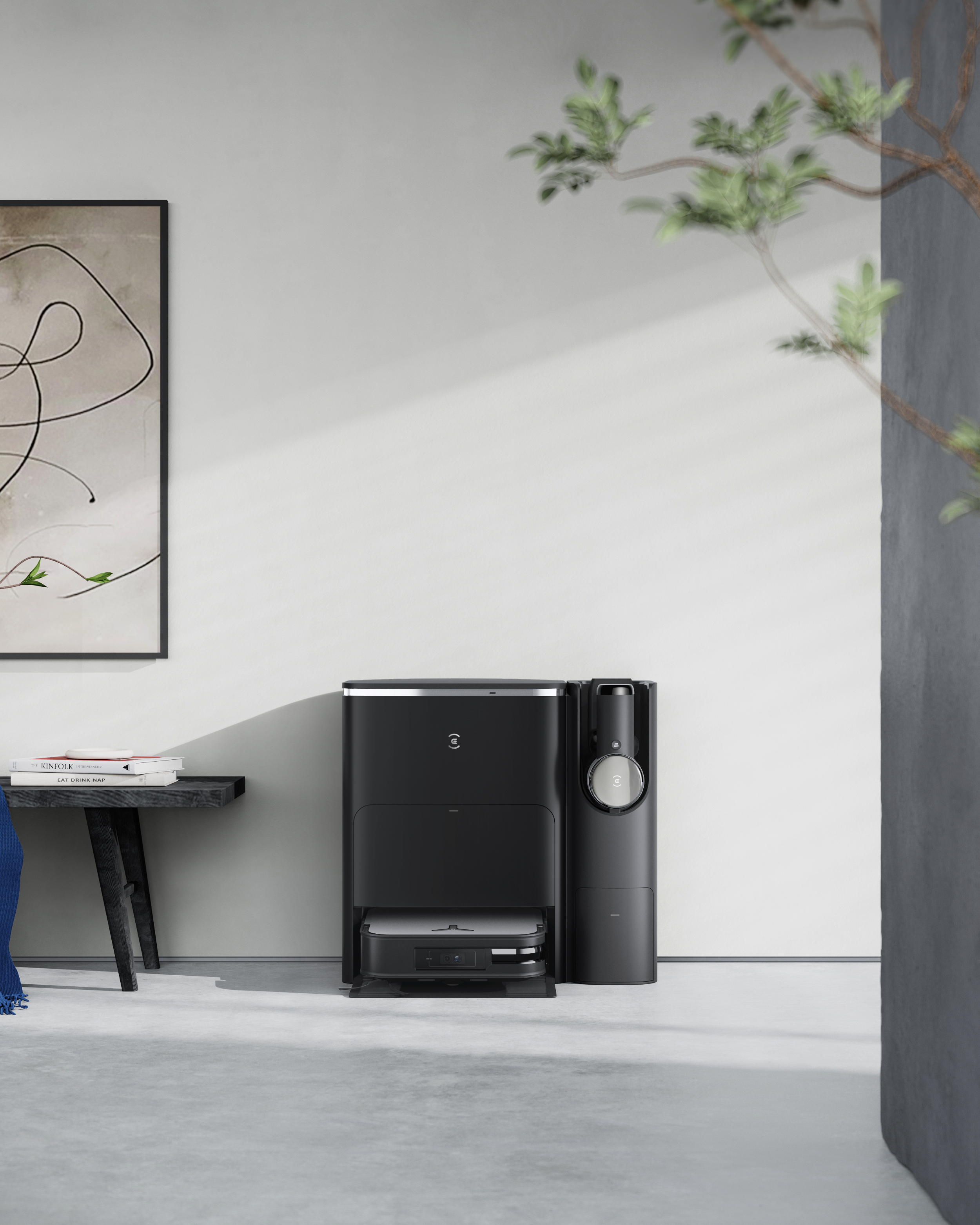 Czarny robot sprzątający w nowoczesnym pokoju ze stołem i sztuką.